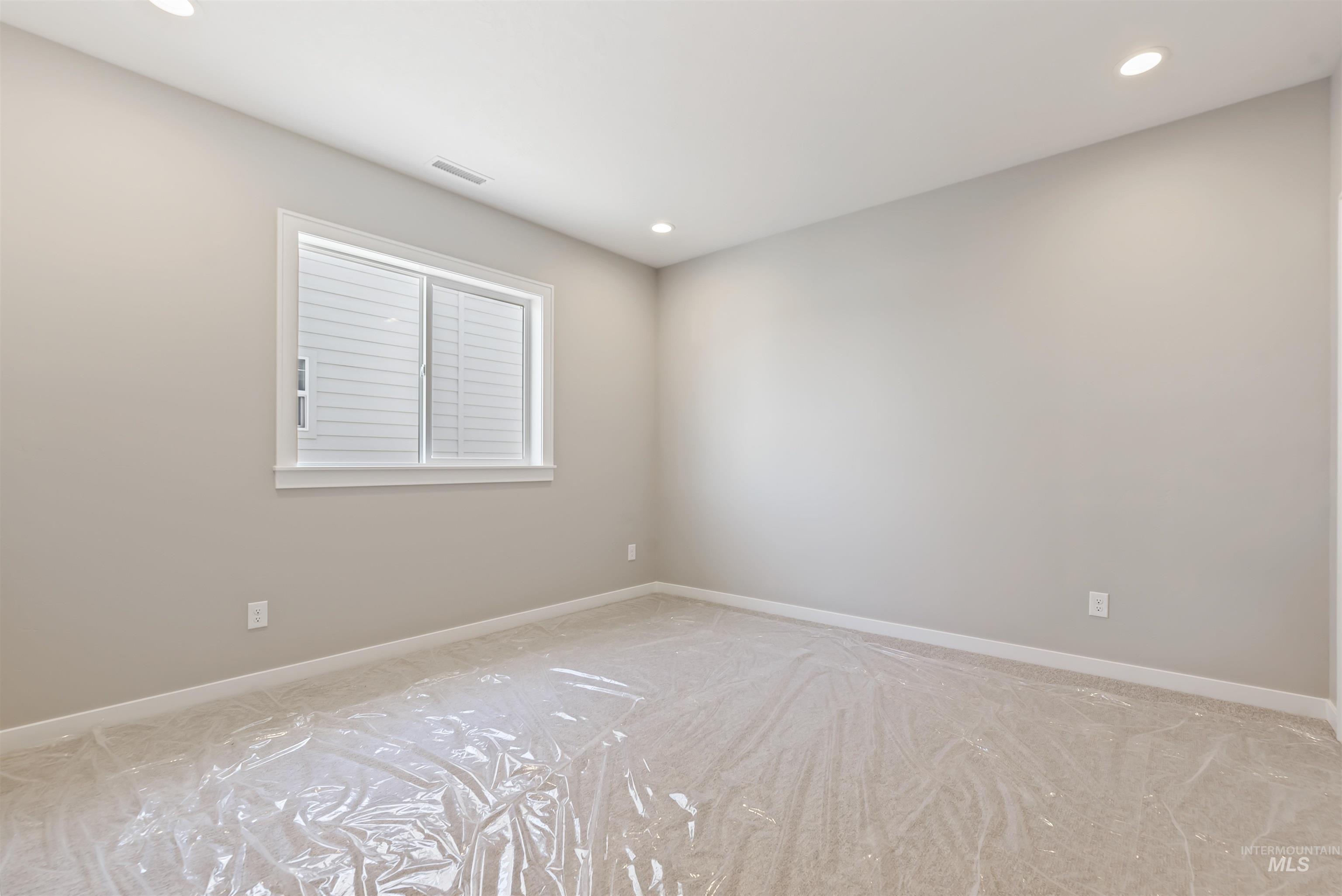 Empty room with recessed lighting and light carpet