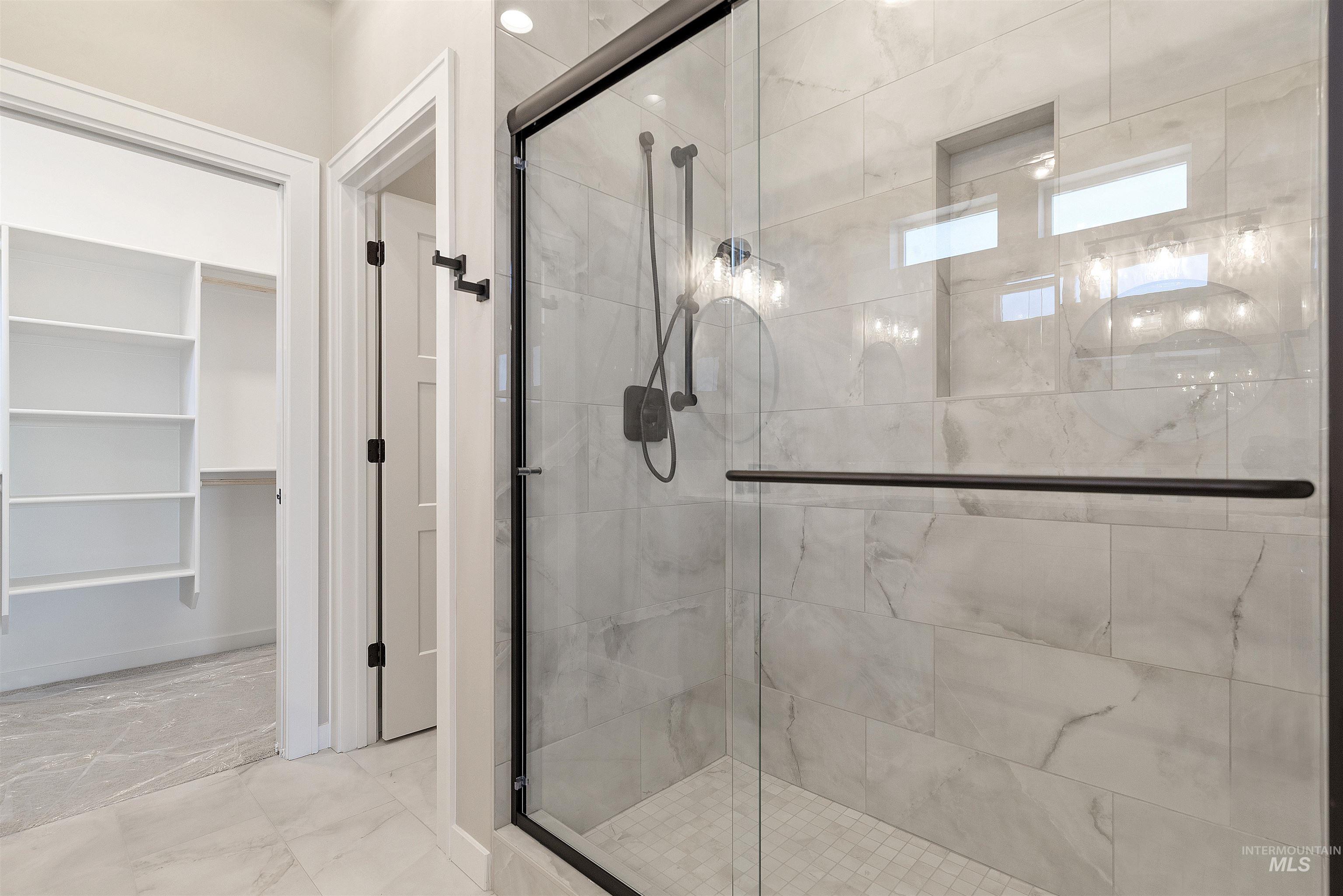 master Bathroom featuring marble finish flooring and a shower stall