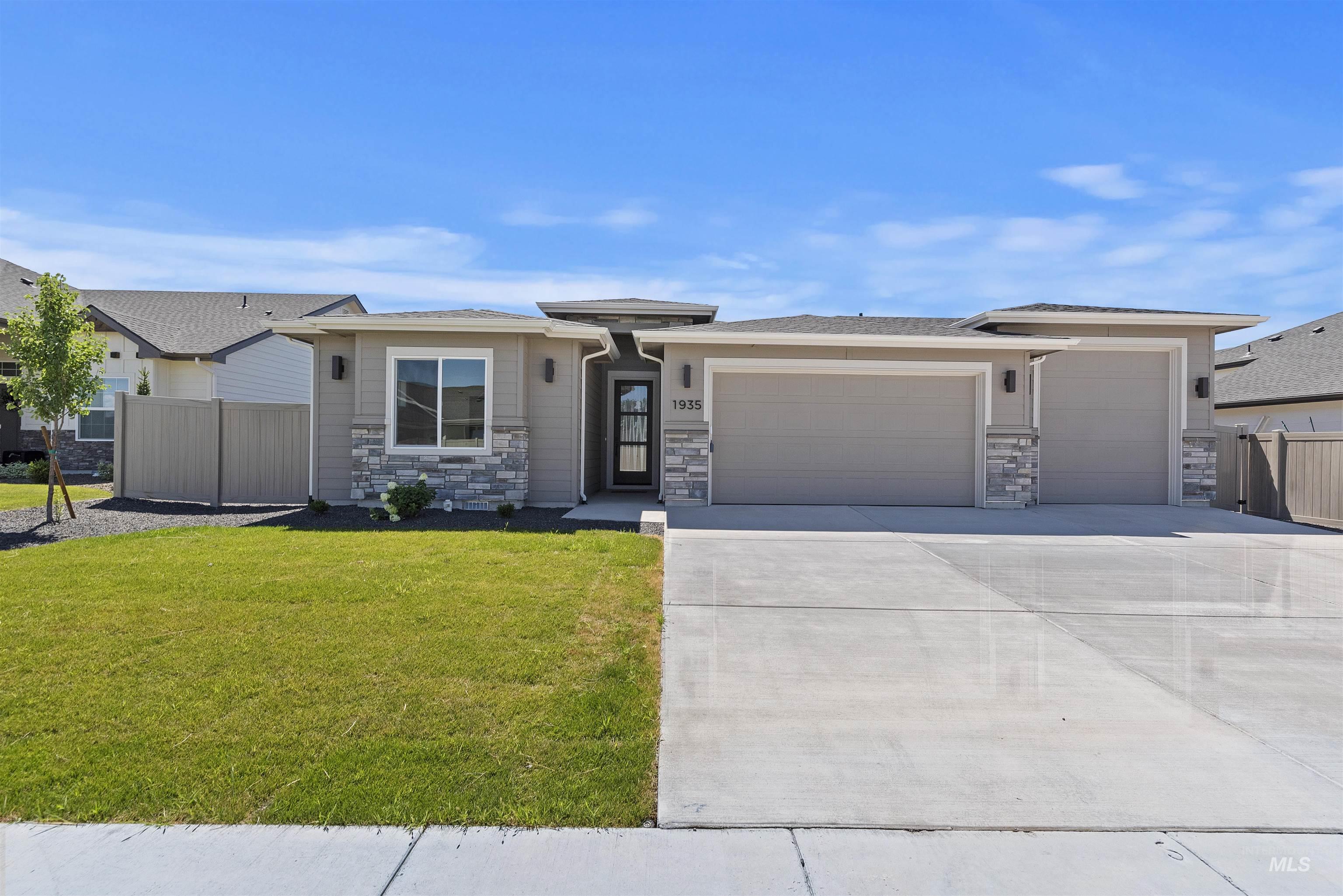 Prairie-style home featuring an attached garage, stone siding, concrete driveway, and a shingled roof