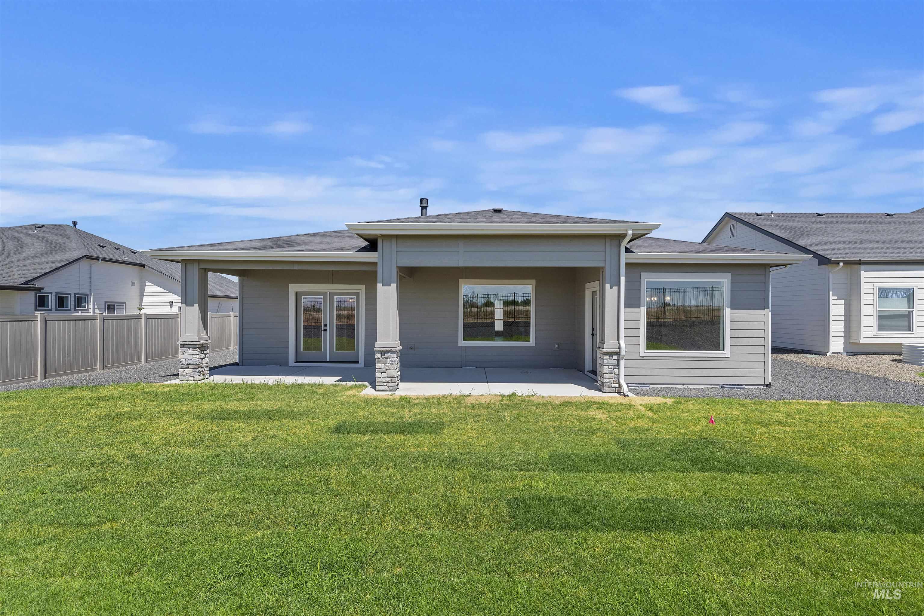 Back of property with french doors, a patio area, and roof with shingles