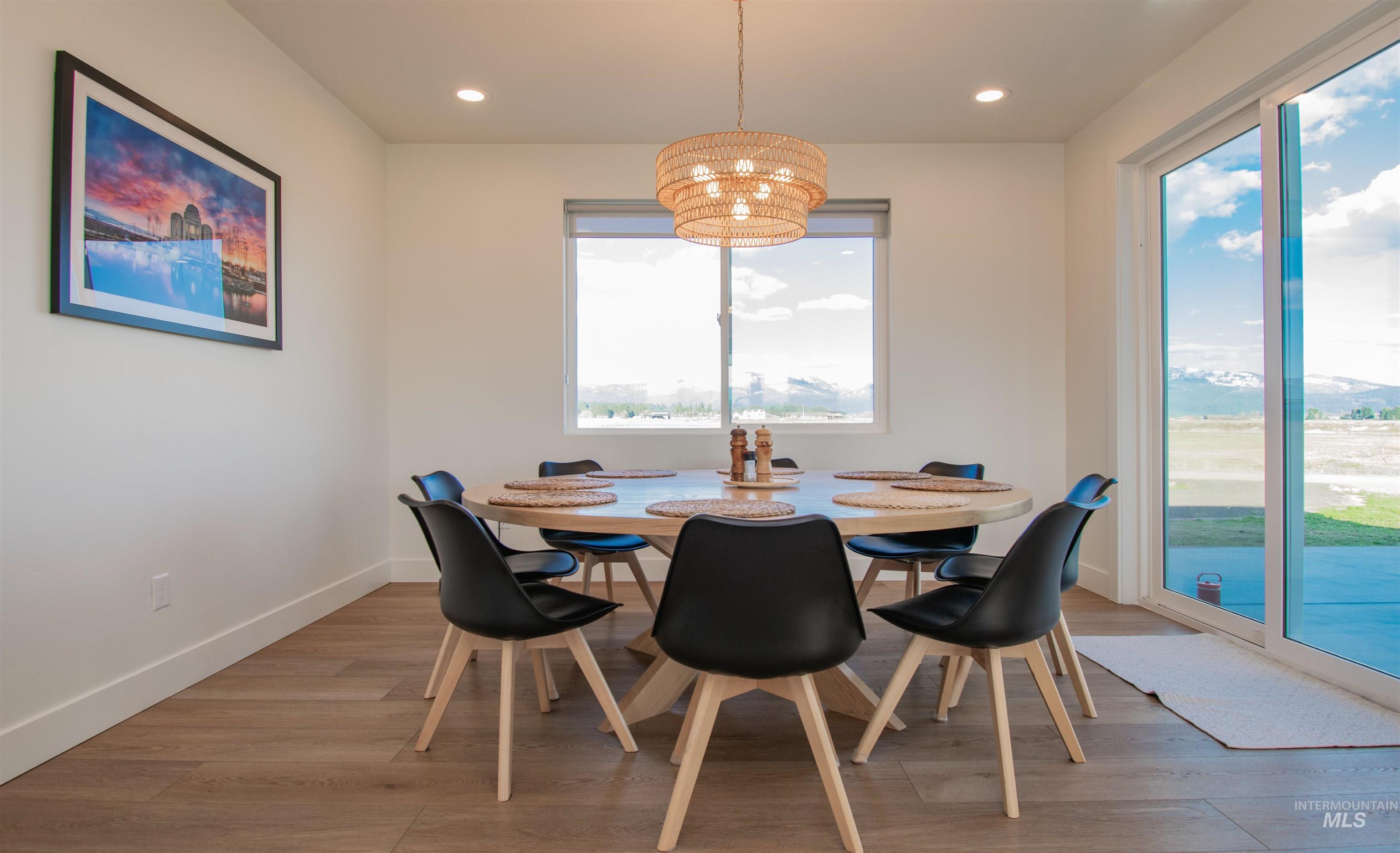 Dining area featuring wood-finish flooring and a contemporary woven pendant light fixture