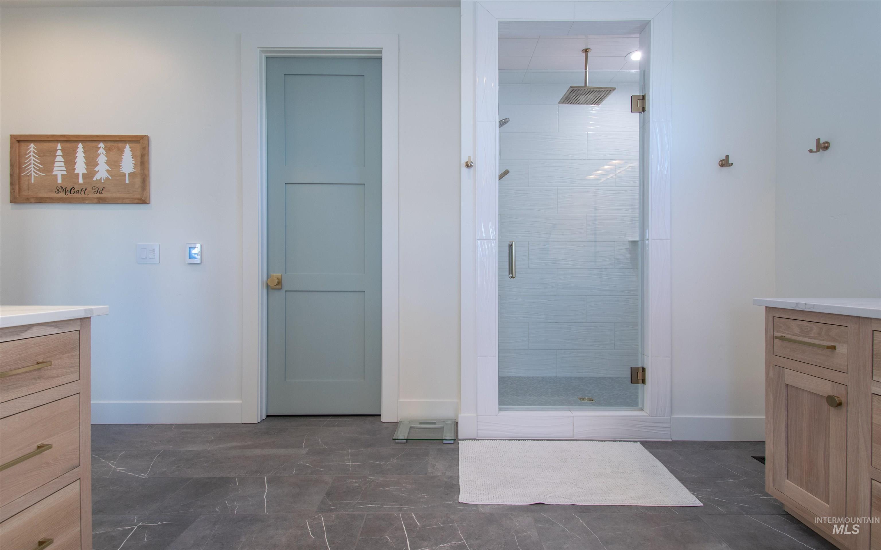 Spacious full bathroom featuring a glass-enclosed shower with subway tile surround, rainfall showerhead, and multiple body jets