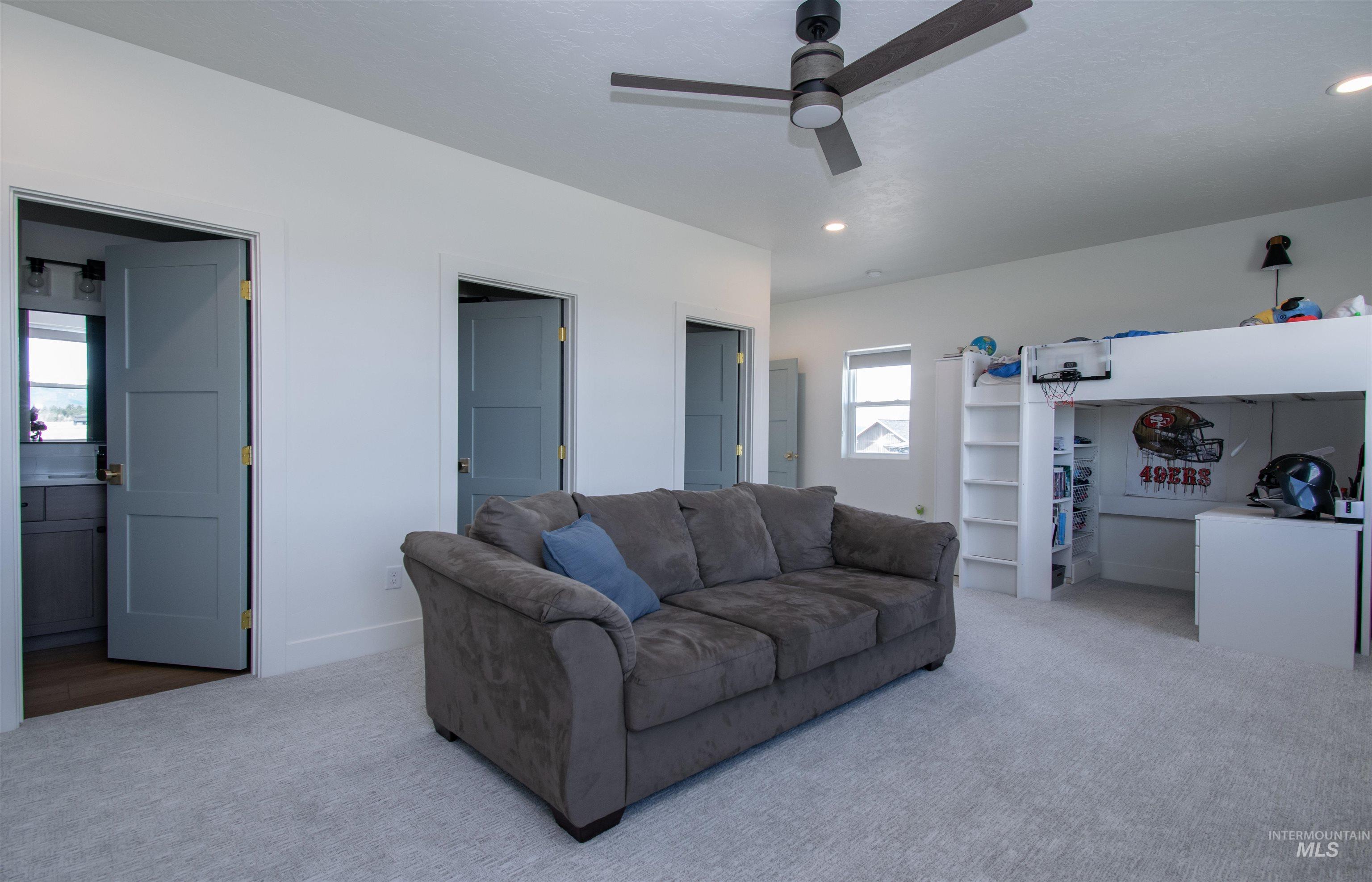 Spacious room featuring light gray carpeting, a contemporary ceiling fan, recessed lighting, and white walls