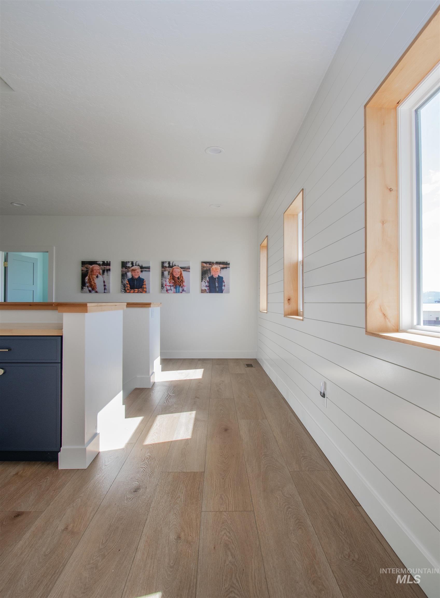Light wood-finish flooring extending through the space