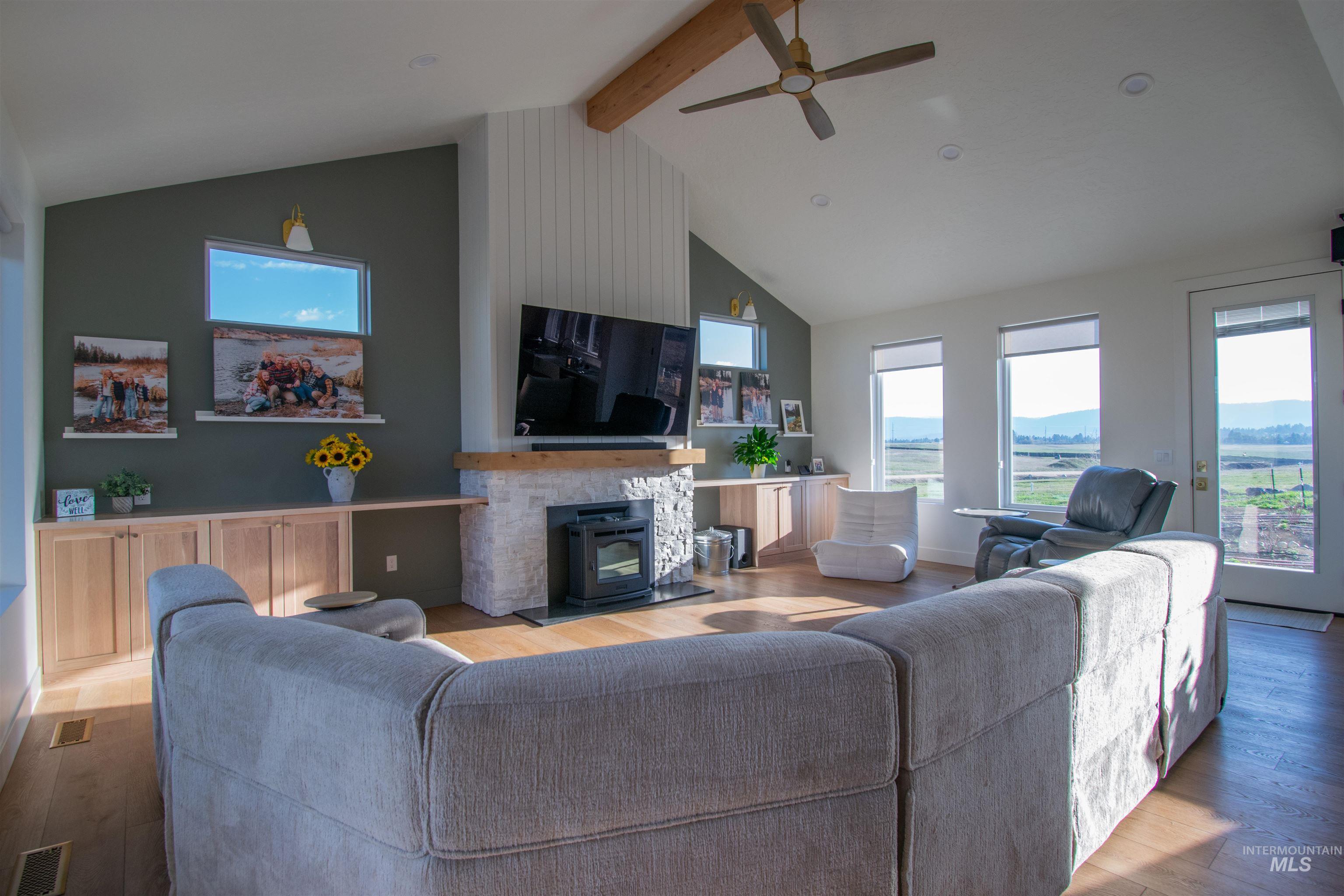 Spacious living area featuring a vaulted ceiling with exposed wood beam, a ceiling fan, and recessed lighting