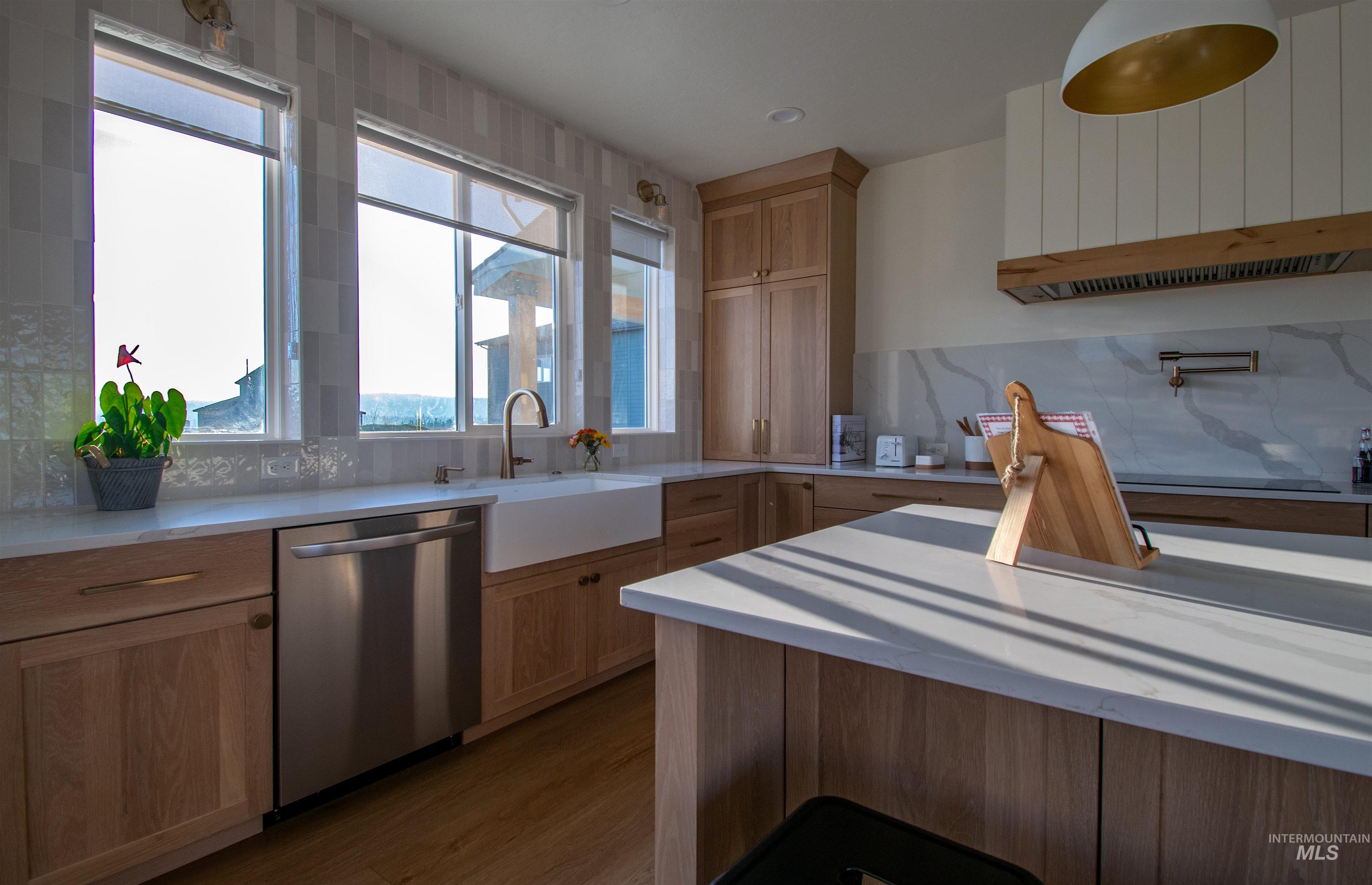 Modern kitchen featuring light wood cabinetry and a large center island with a light-toned countertop