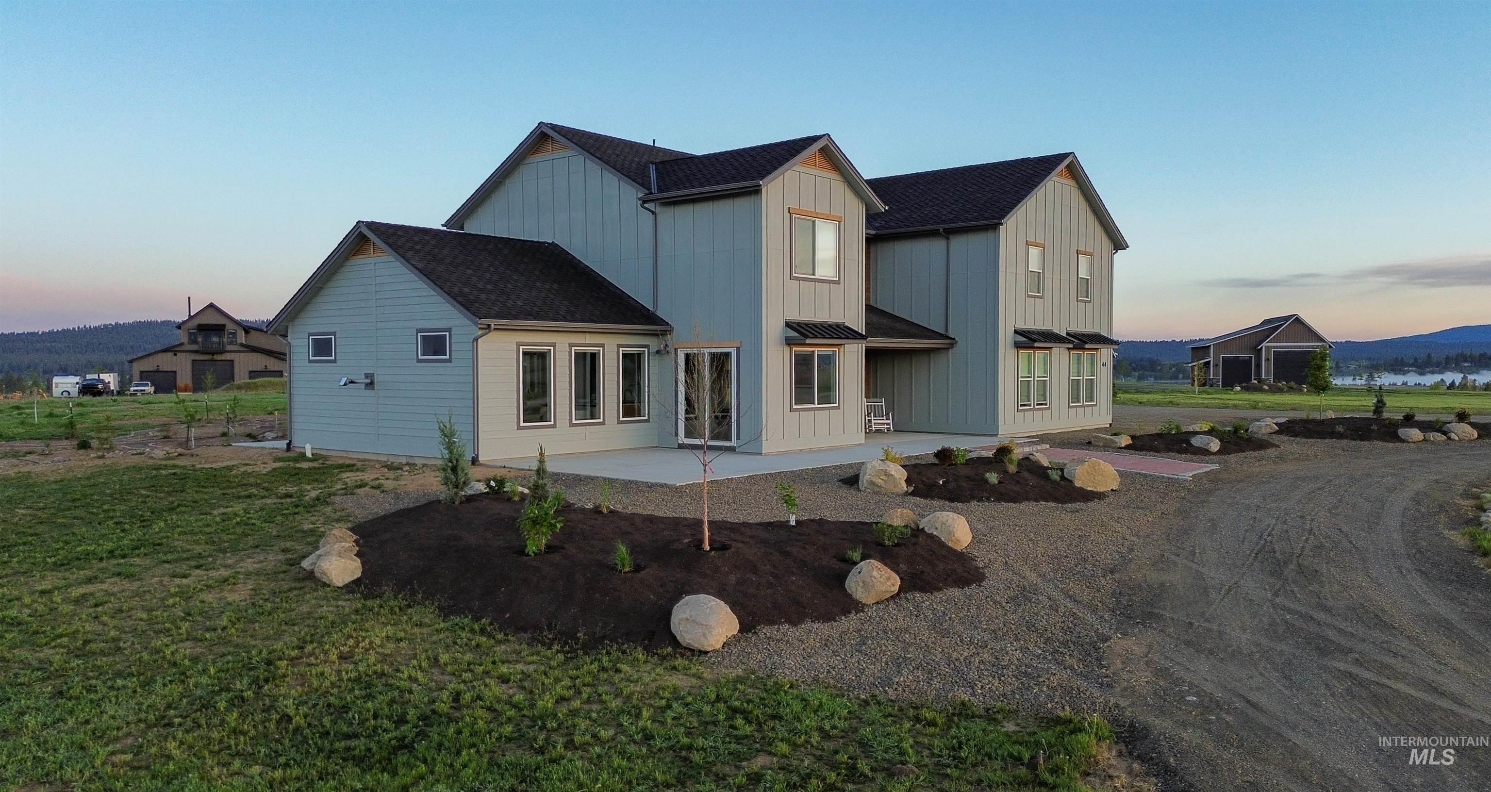 Contemporary two-story residence featuring light blue vertical siding and dark shingle roofing