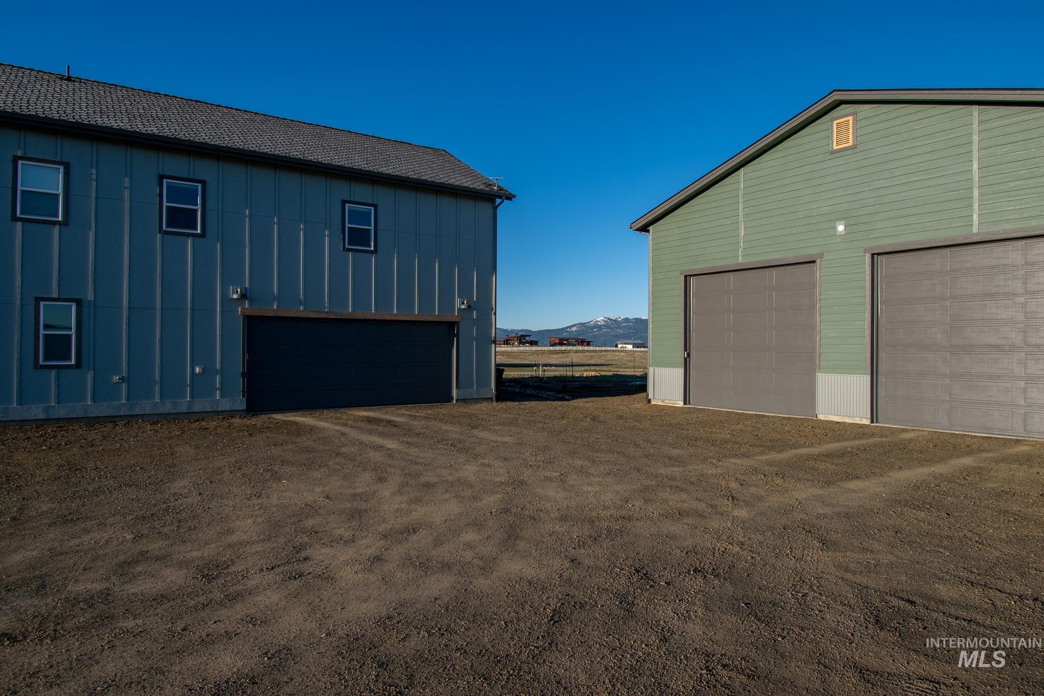 Two distinct structures featuring corrugated metal siding and multiple garage bays