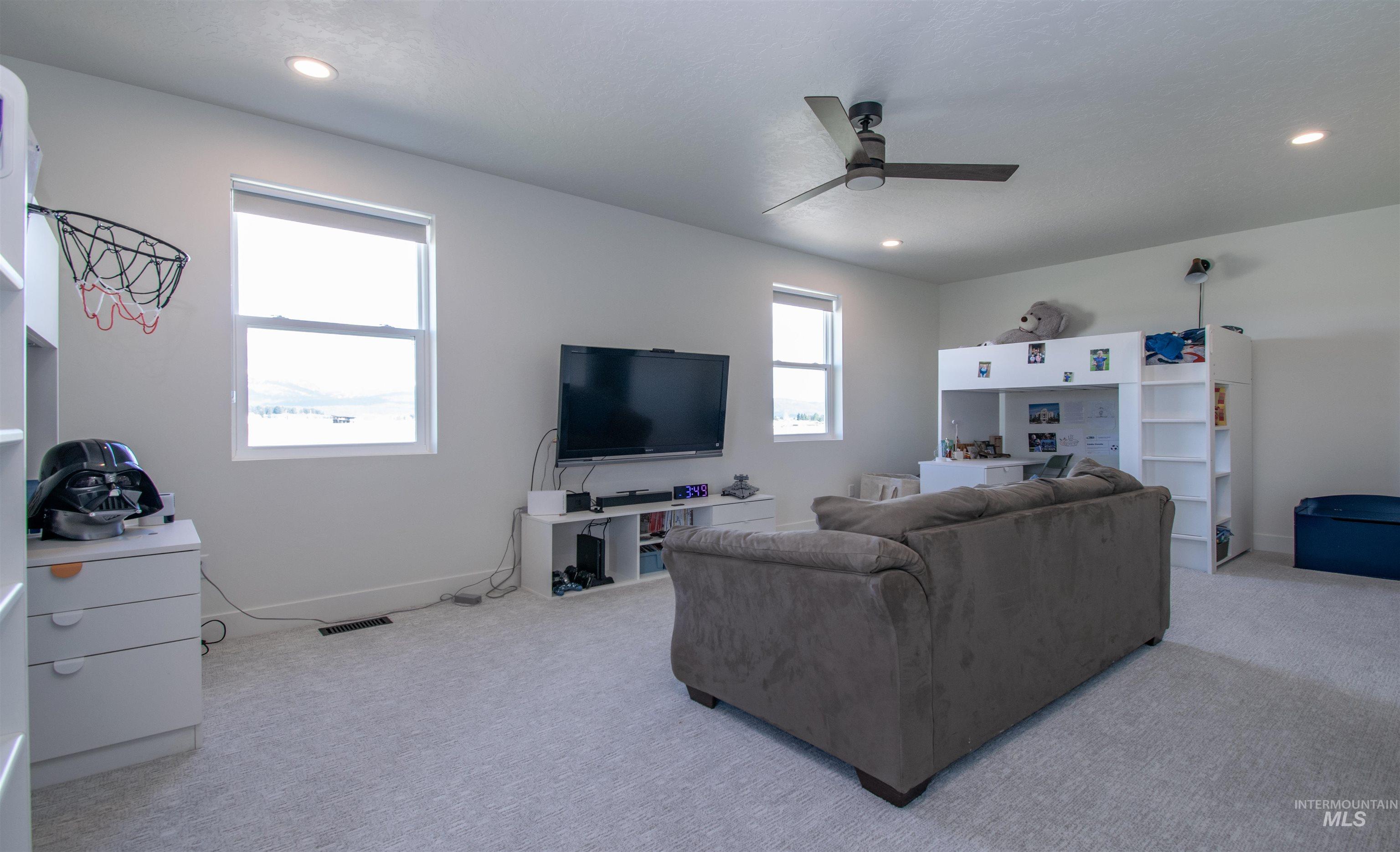 Spacious room featuring light-colored carpeting and bright white walls