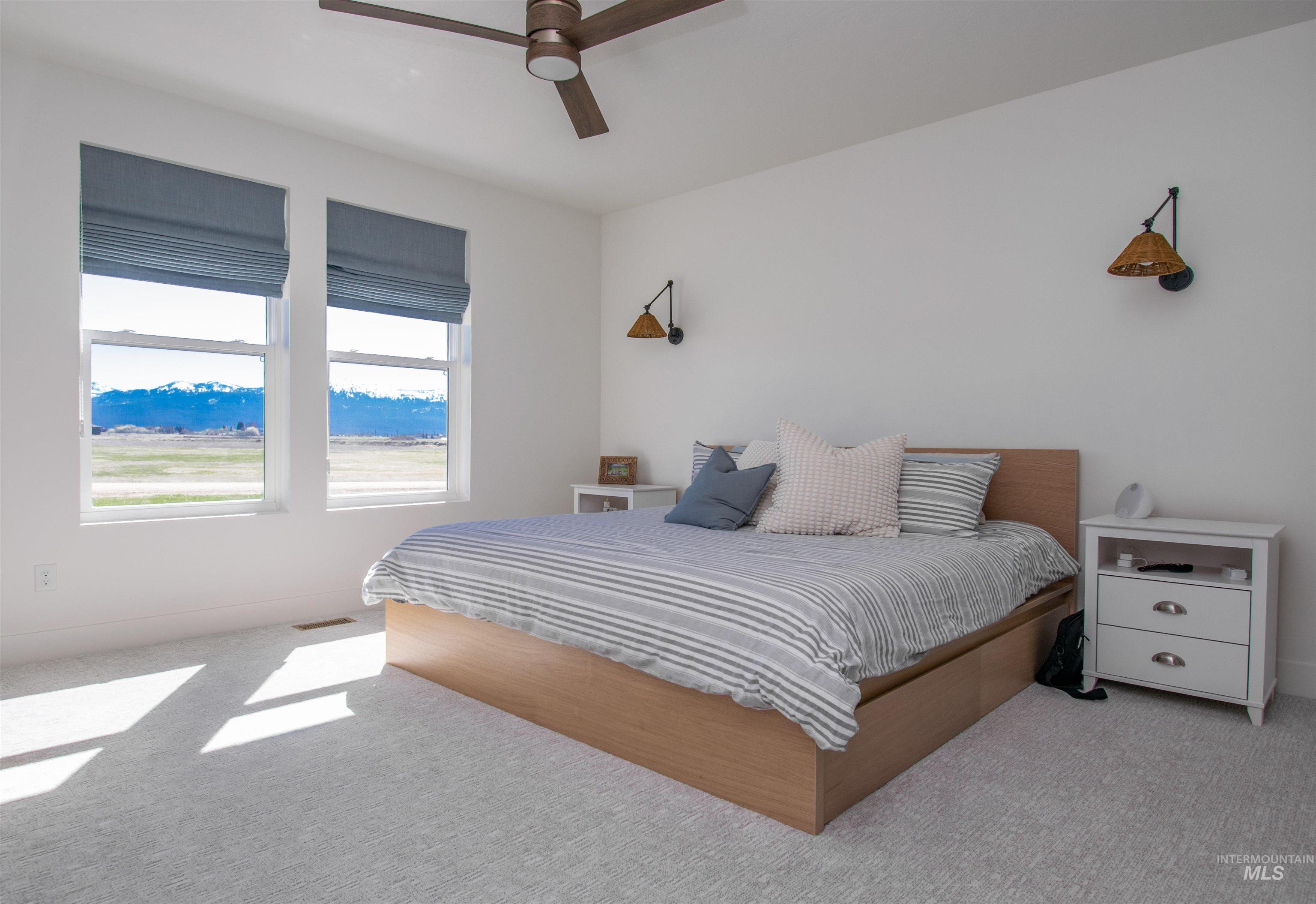 White-walled room featuring two large windows with blue Roman shades