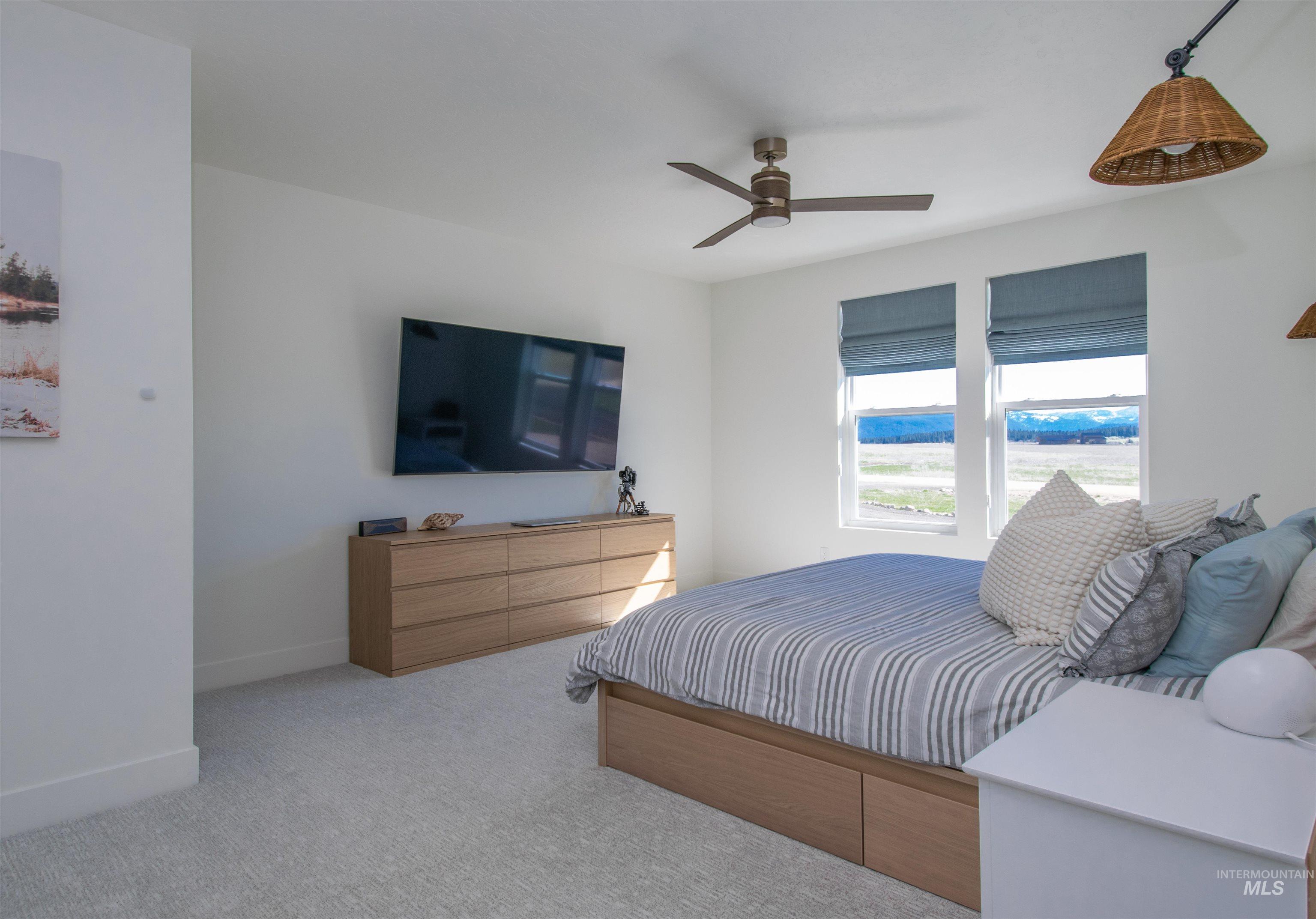 Bright room featuring two windows with blue fabric Roman shades