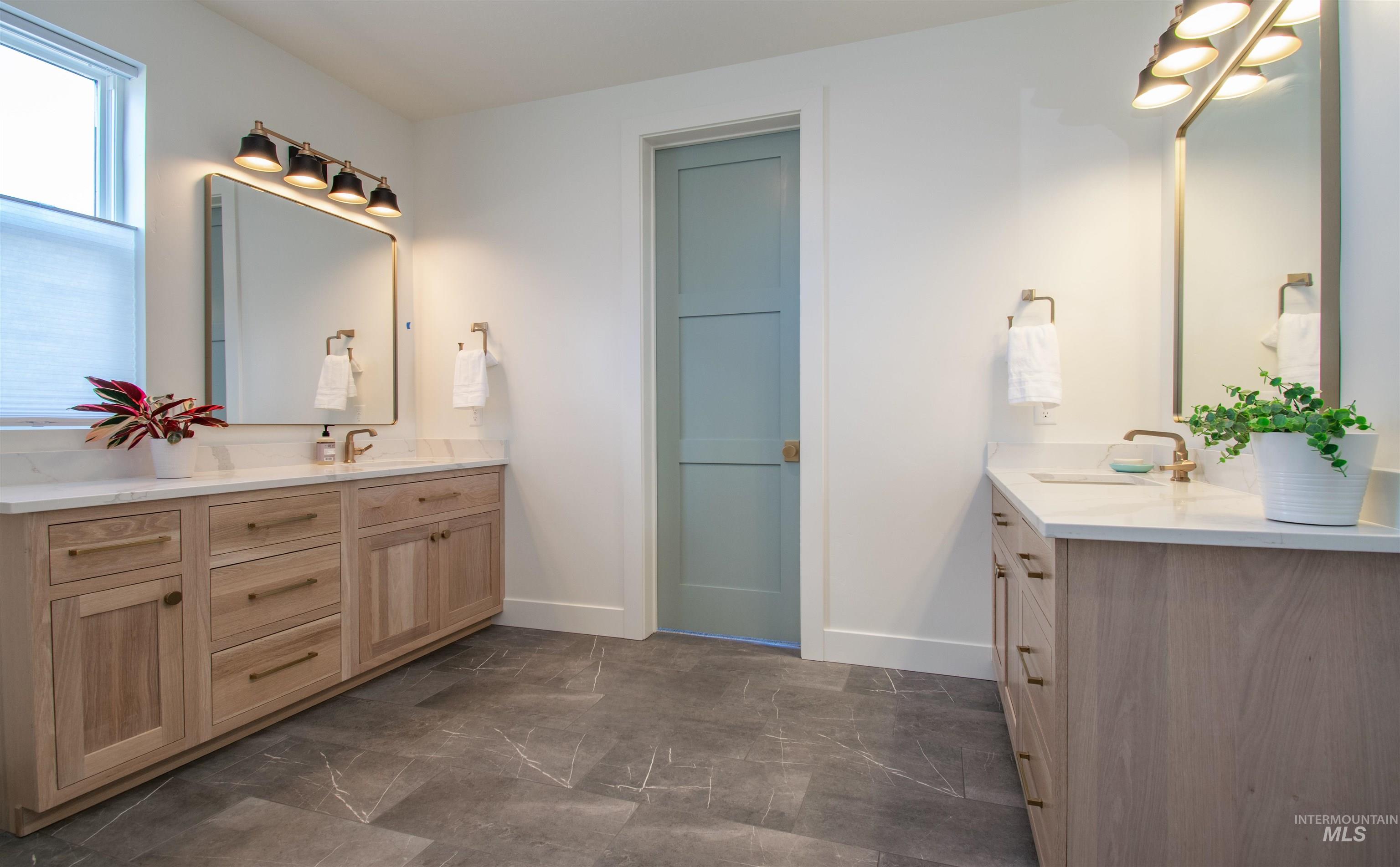 Dual vanity bathroom featuring light wood-finish cabinetry and white countertops
