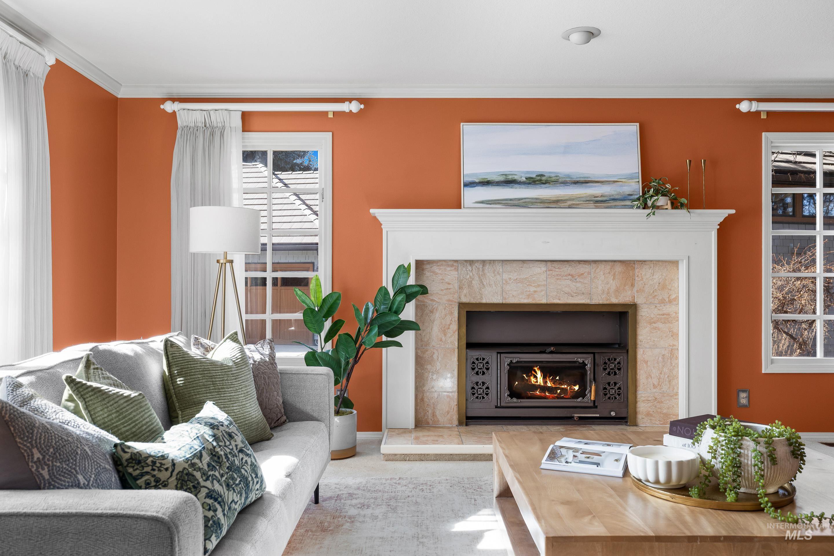 Living area featuring crown molding and a tiled fireplace