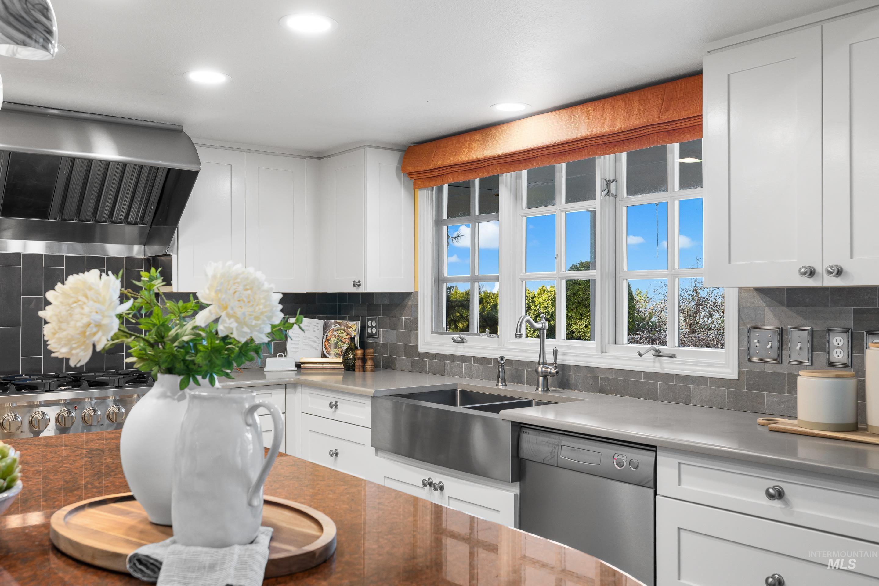 Kitchen featuring white cabinets, dishwasher, exhaust hood, tasteful backsplash, and recessed lighting