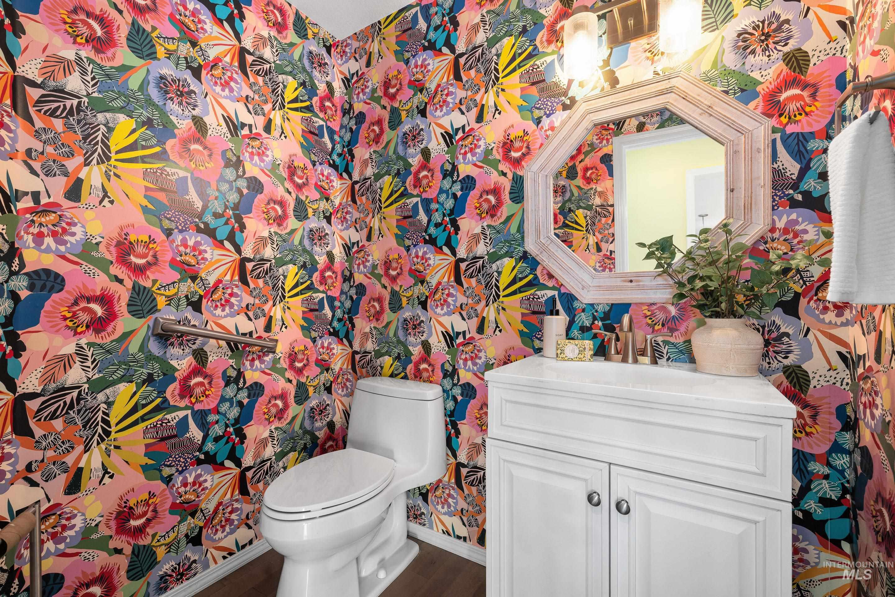 Bathroom with wallpapered walls and vanity