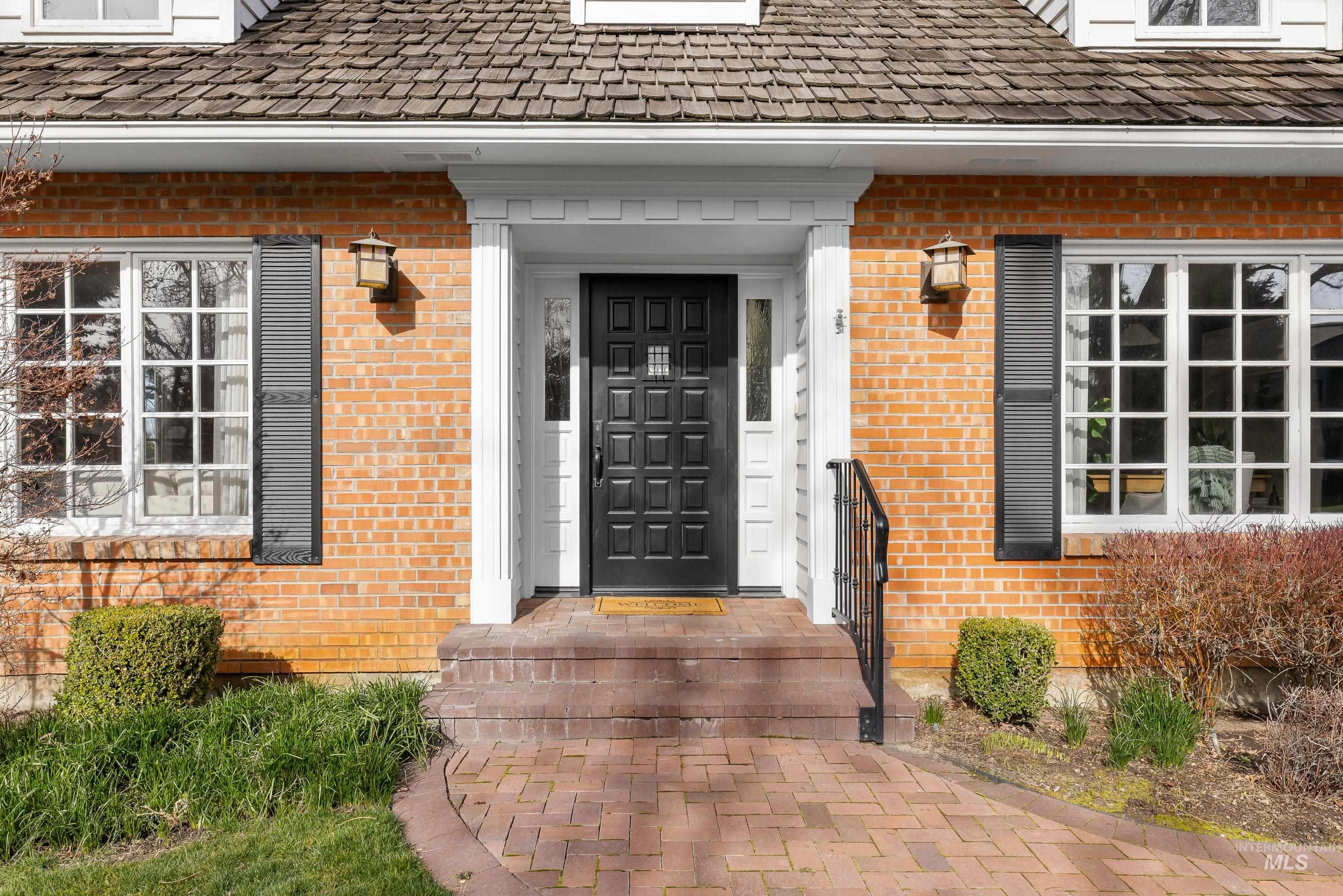 Doorway to property featuring brick siding