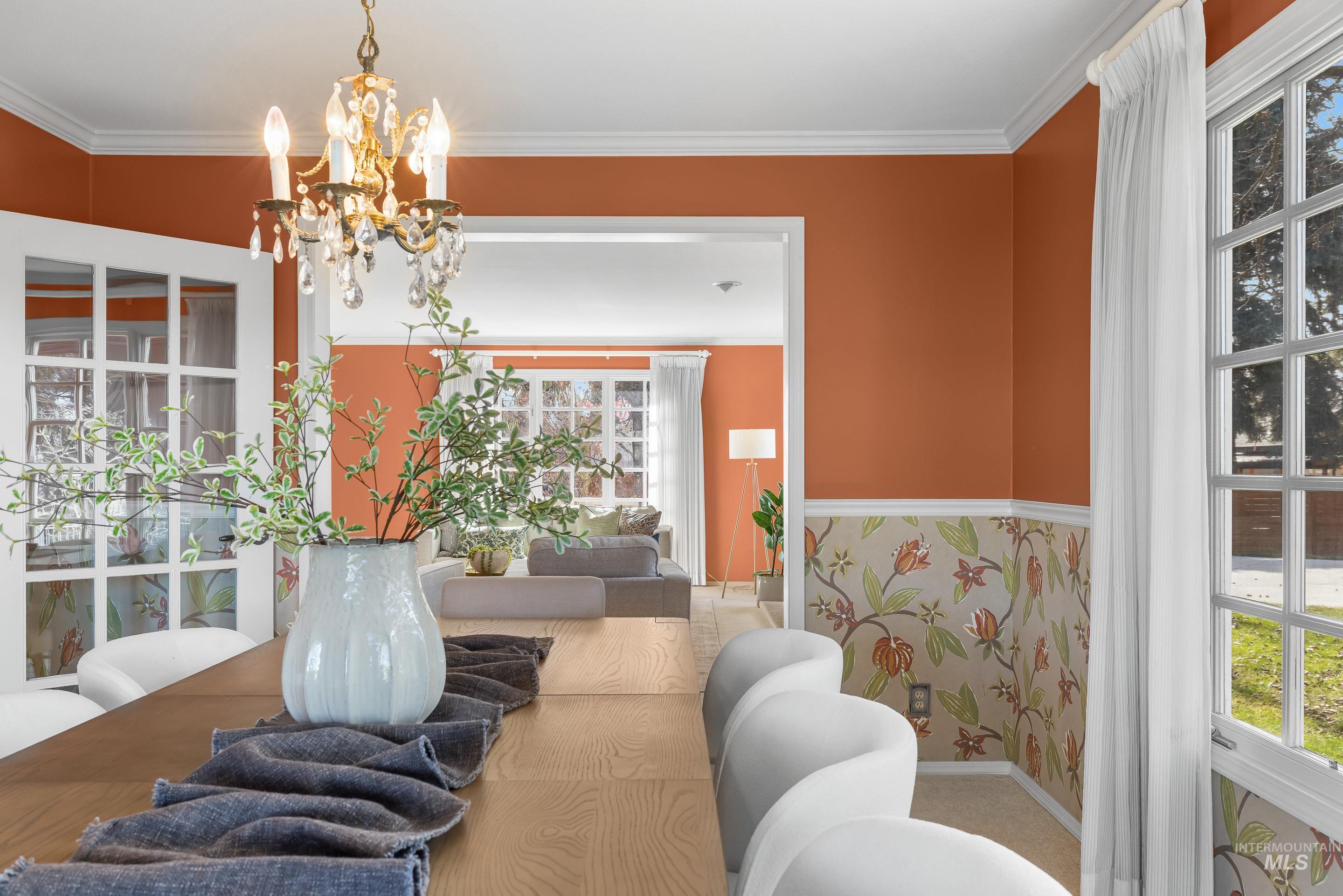 Dining room with healthy amount of natural light, suspended lighting, and crown molding