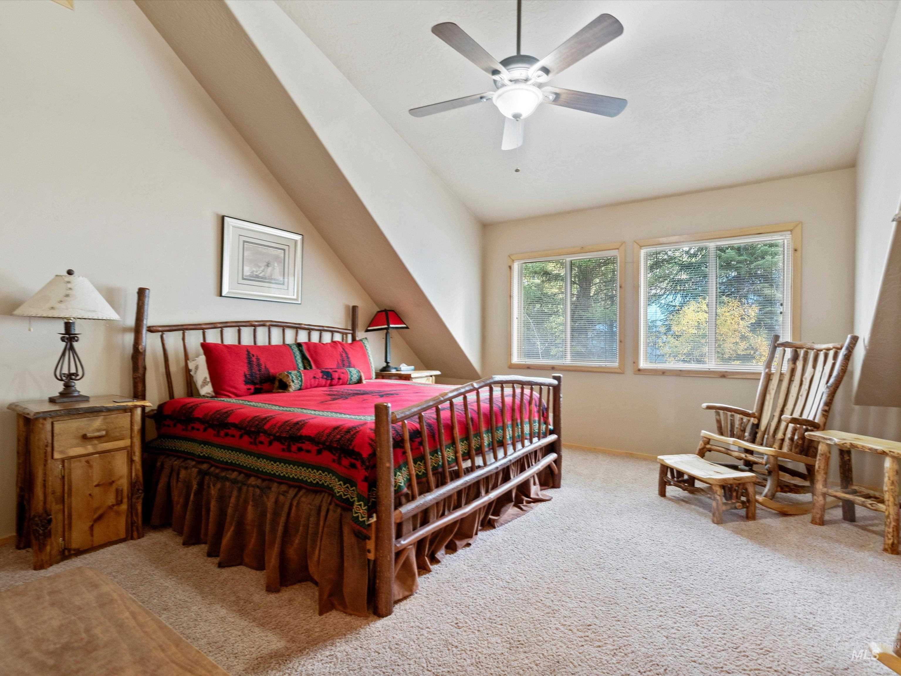 Bedroom featuring light colored carpet, a ceiling fan, and vaulted ceiling