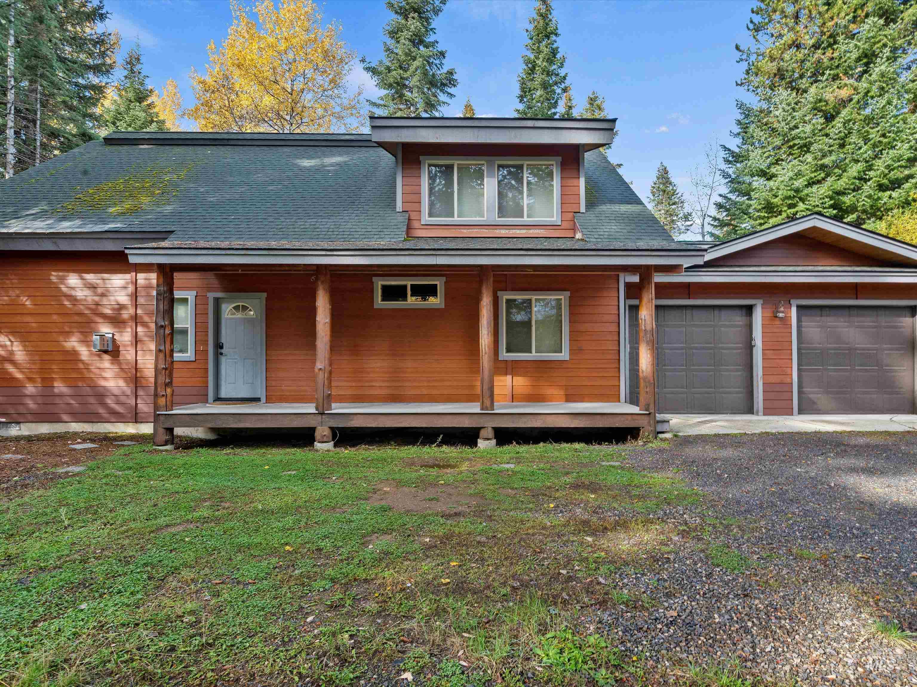 View of front of property with a porch, an attached garage, roof with shingles, and driveway