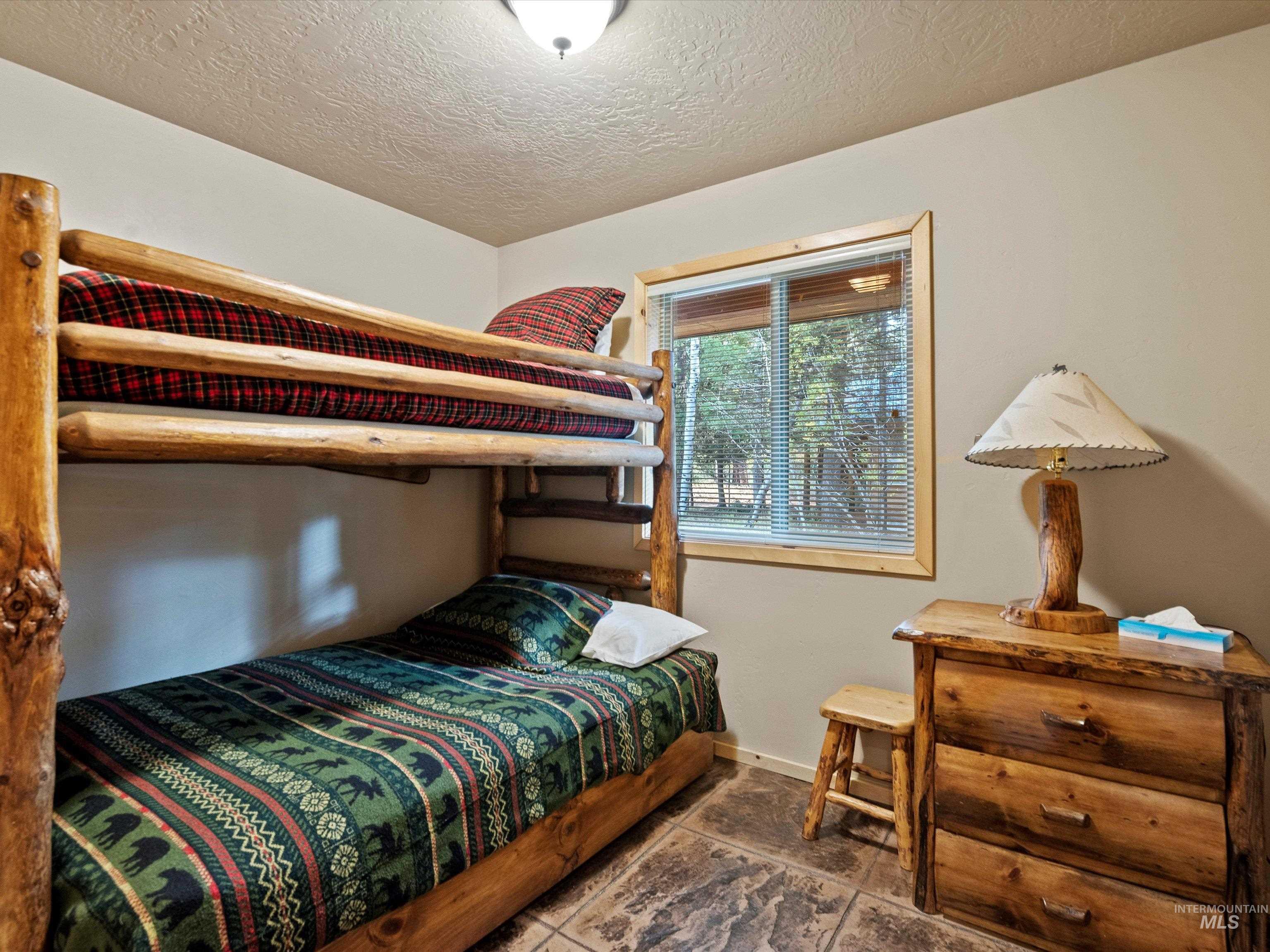 Bedroom with a textured ceiling and baseboards