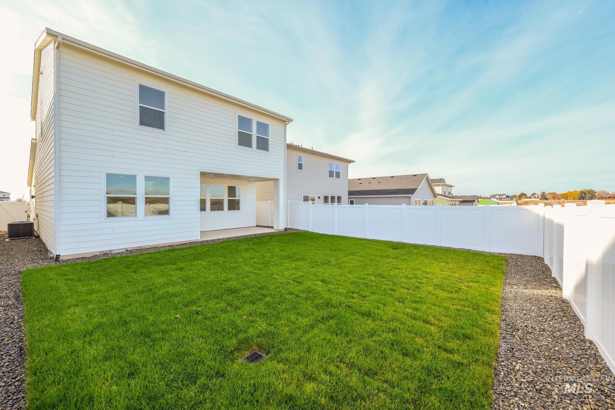 Rear view of house featuring a patio area and a fenced backyard