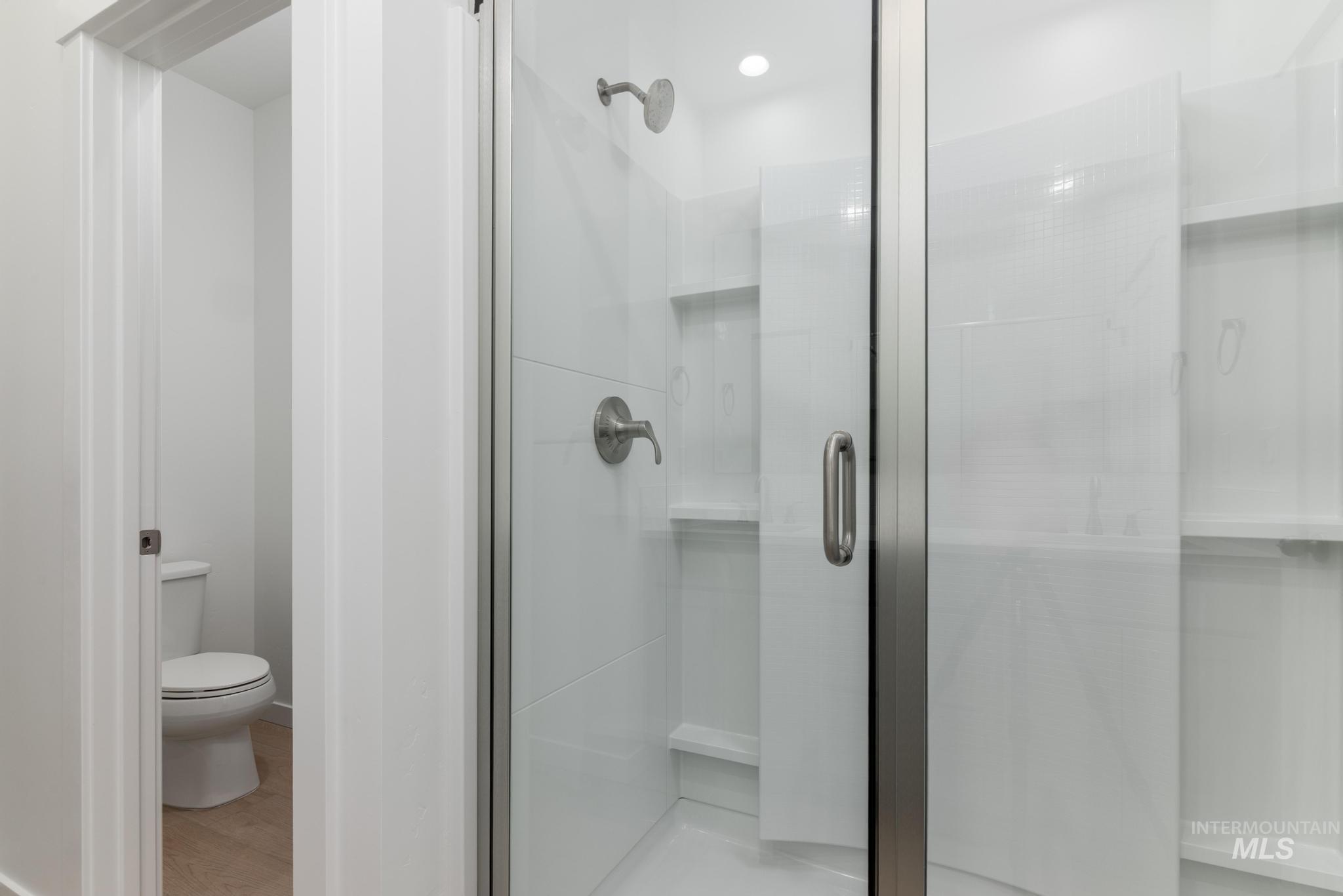 Bathroom with a stall shower and light wood-style flooring
