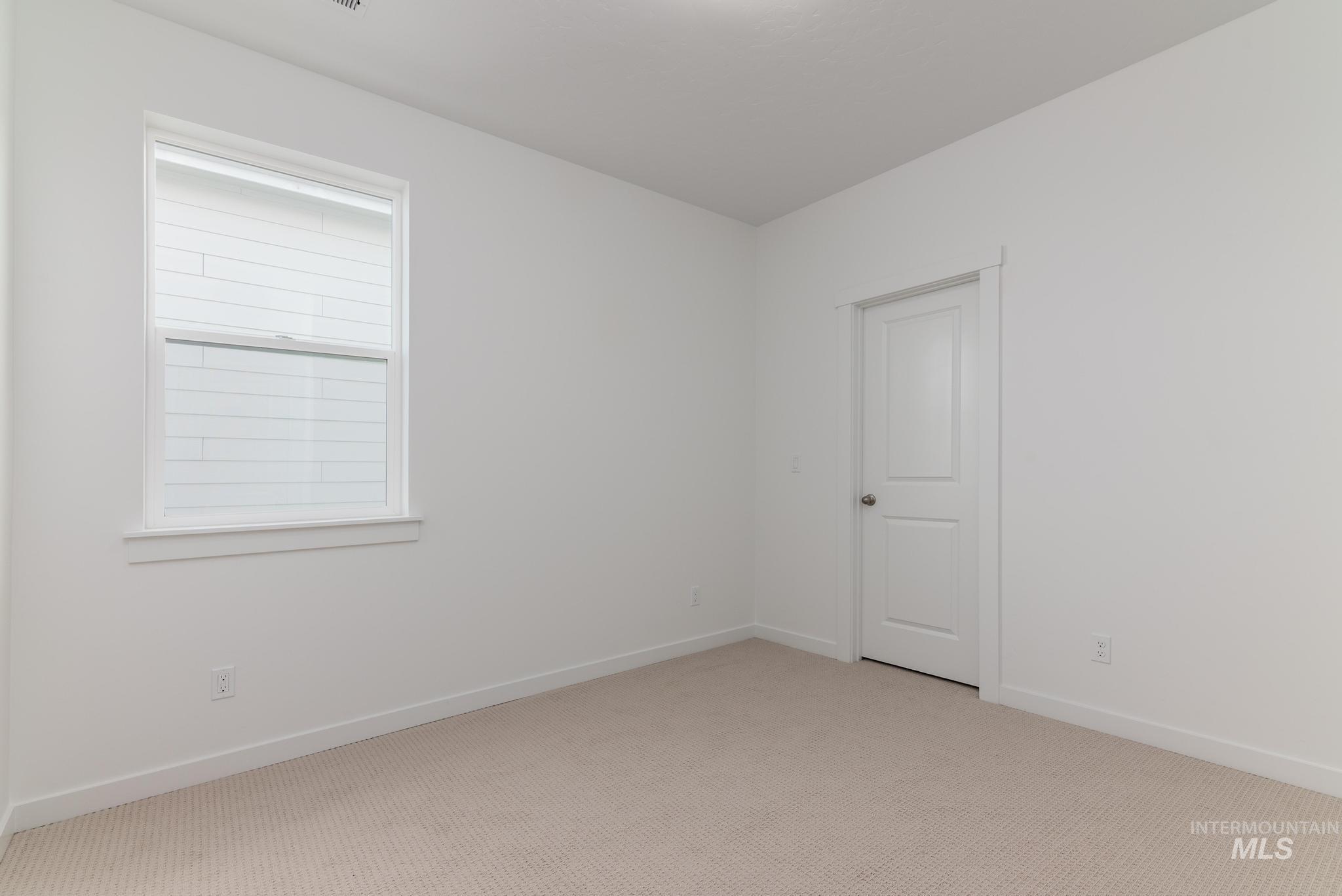 Carpeted spare room with baseboards