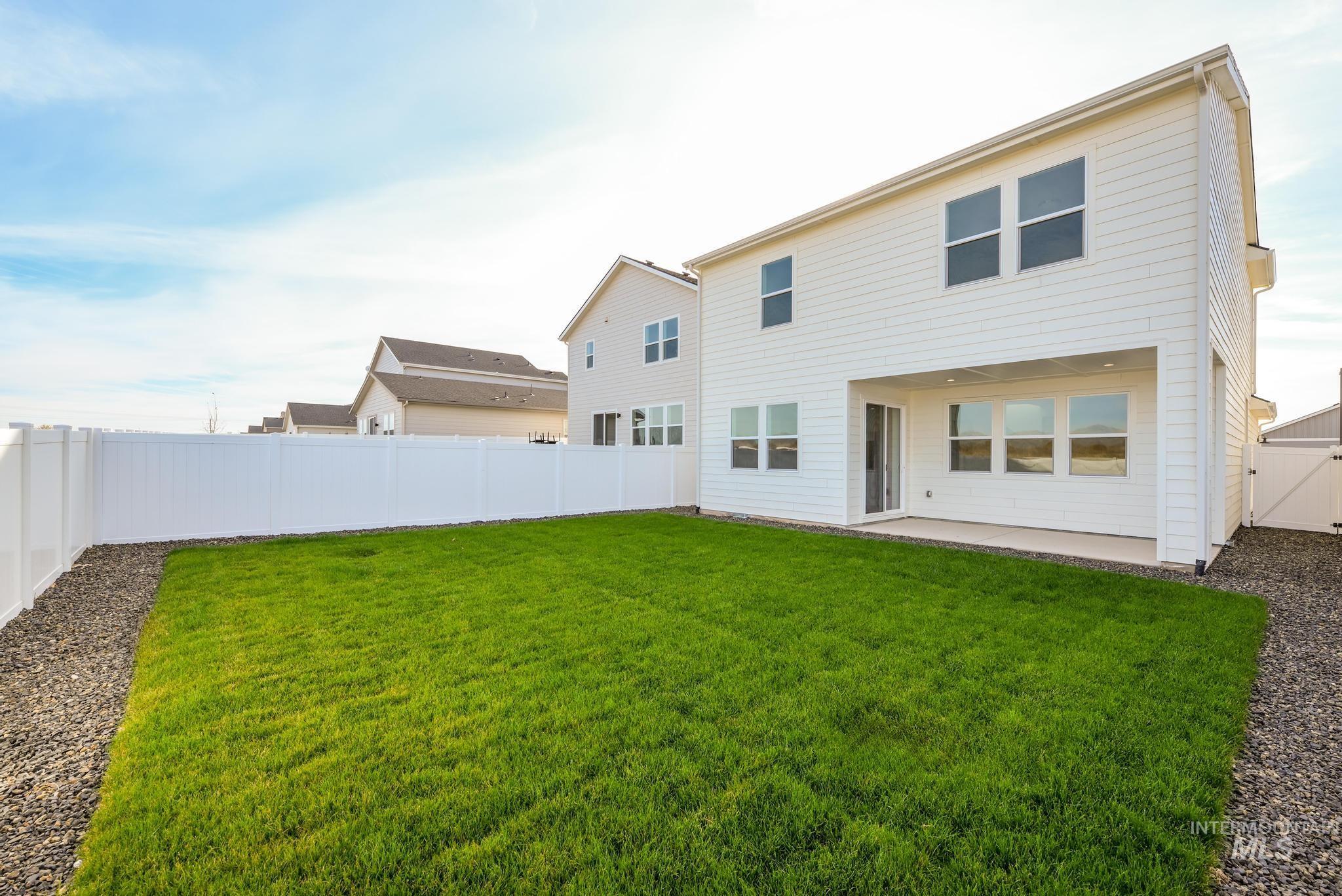 Rear view of house featuring a fenced backyard and a patio
