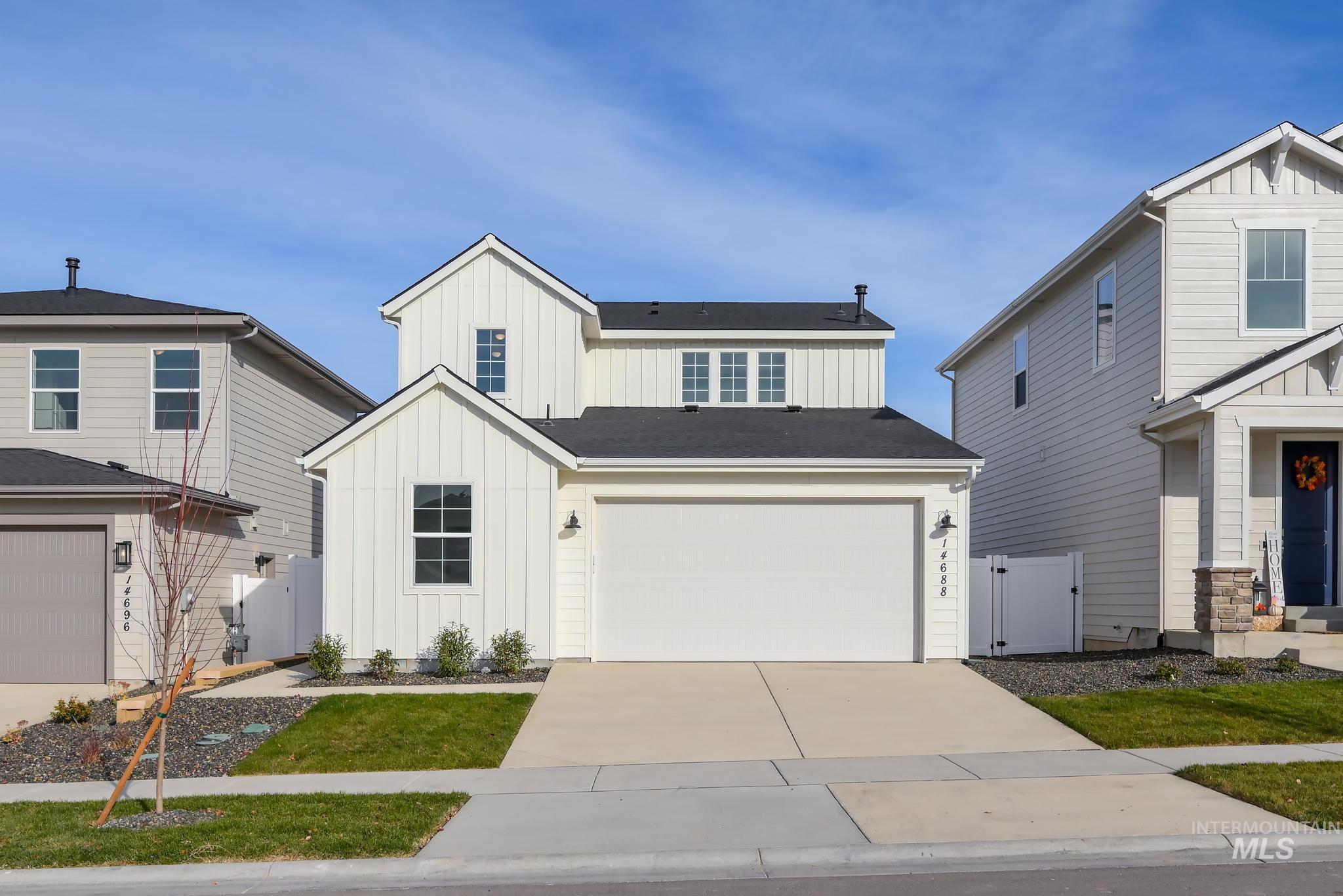 View of front of property with board and batten siding, concrete driveway, and an attached garage