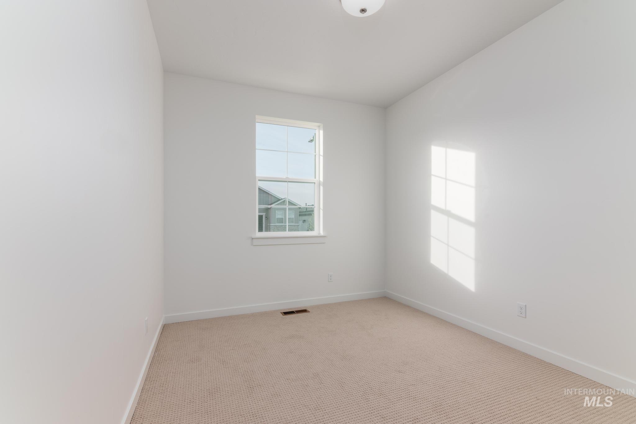 Carpeted empty room featuring baseboards