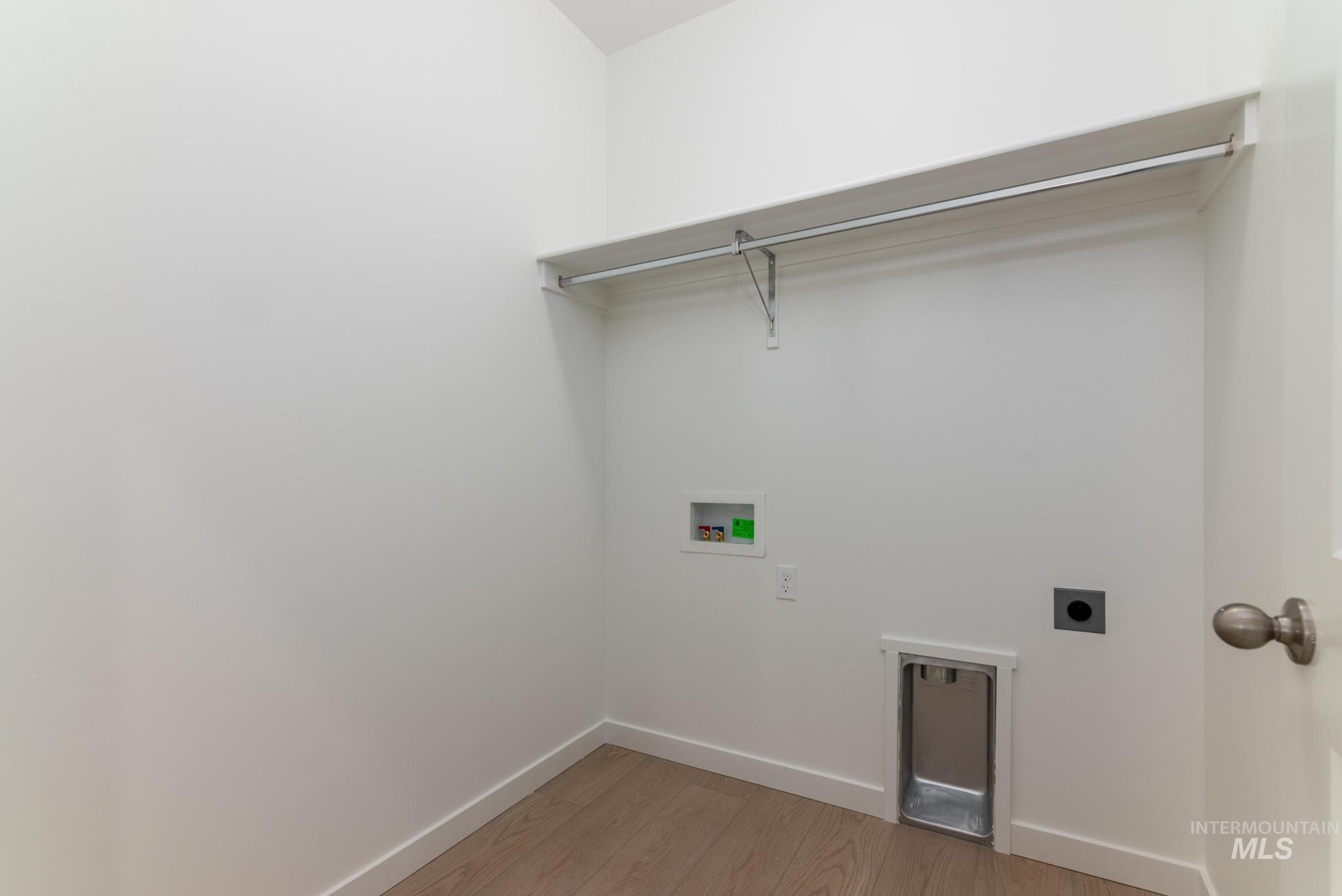 Laundry room featuring electric dryer hookup, light wood-type flooring, and washer hookup