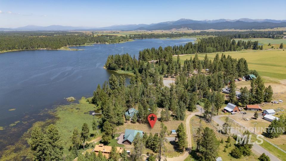Aerial view of property's location featuring a water and mountain view and a heavily wooded area