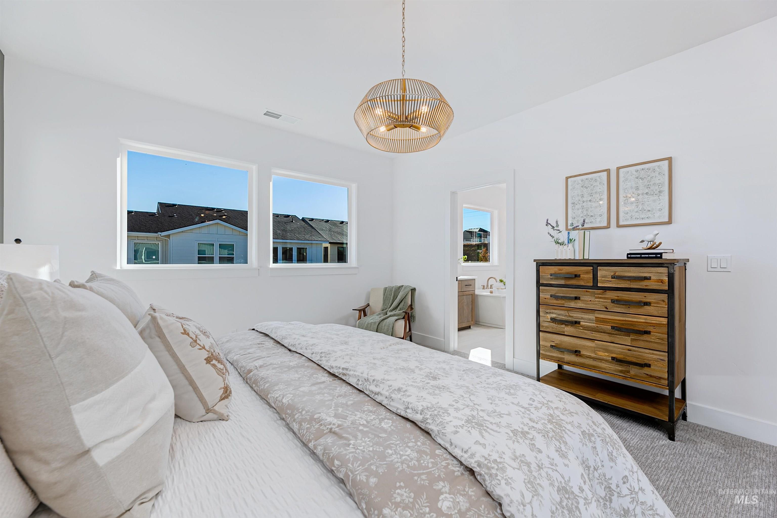 Bright interior space featuring vaulted ceilings, a contemporary ceiling fixture, and twin windows
