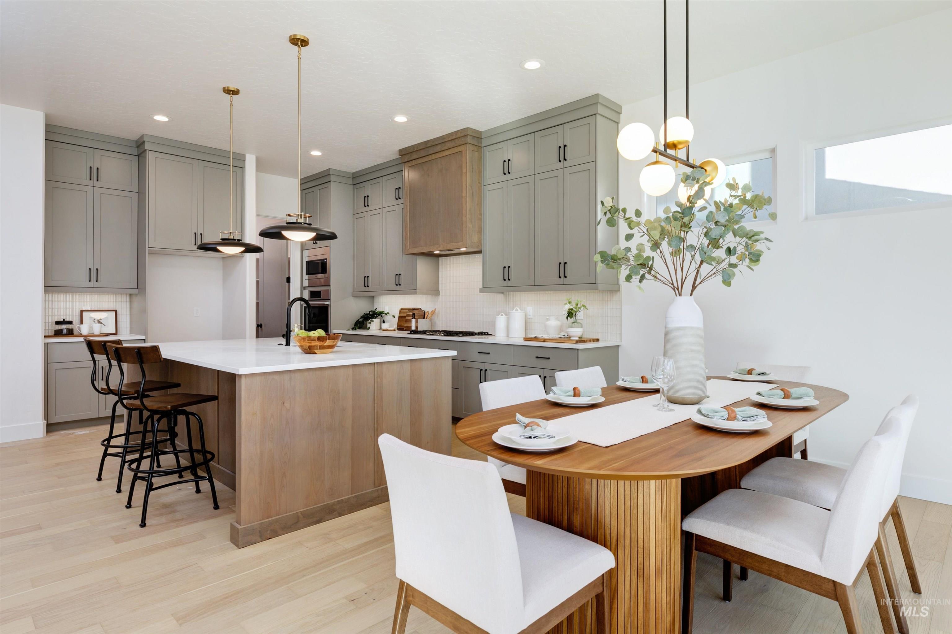 Open-concept kitchen and dining area featuring light wood-finish flooring