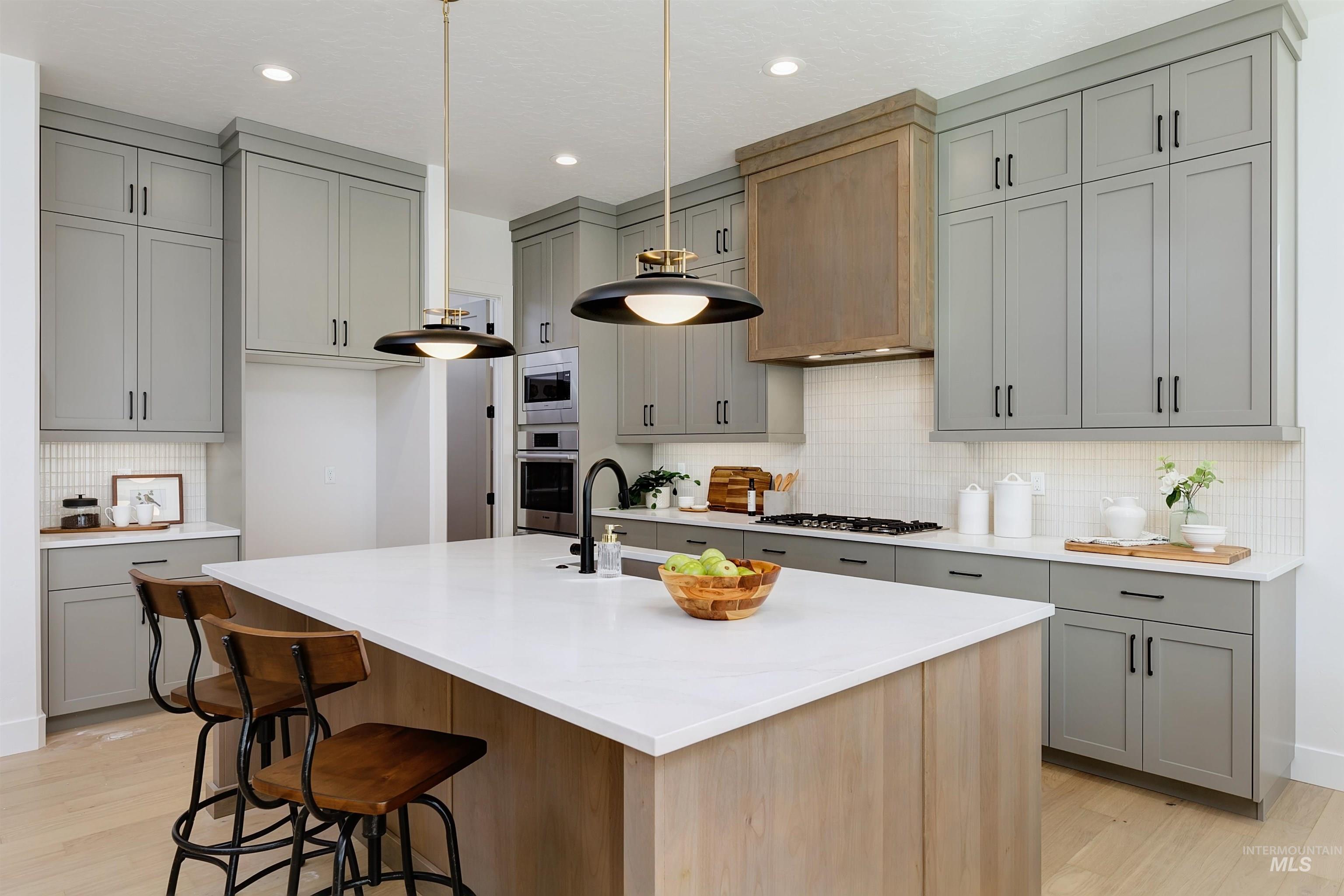 Modern kitchen featuring a large center island with a light wood-finish base and a white countertop