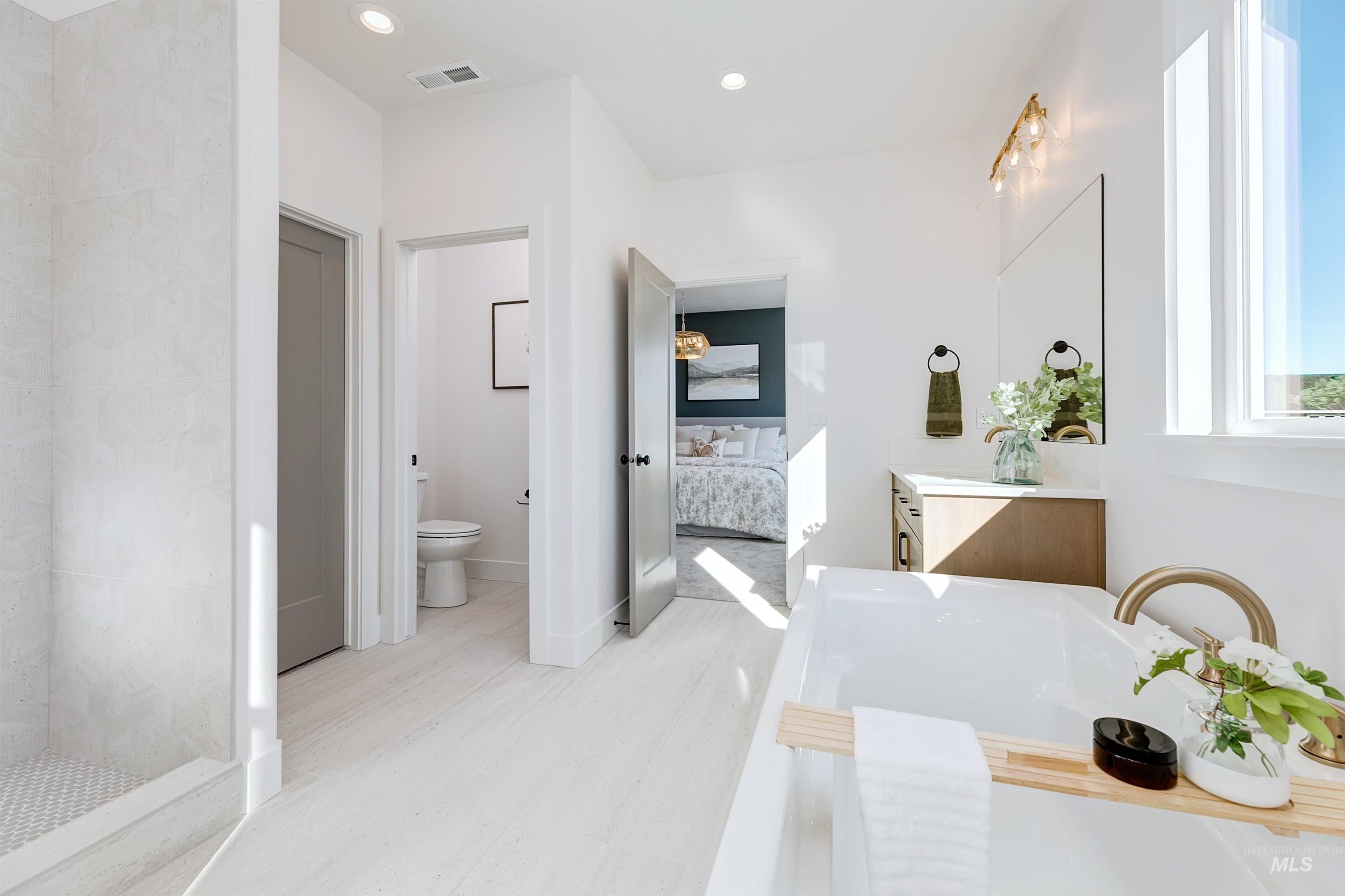 Freestanding soaking tub with gold-finish fixtures and a wood-finish caddy