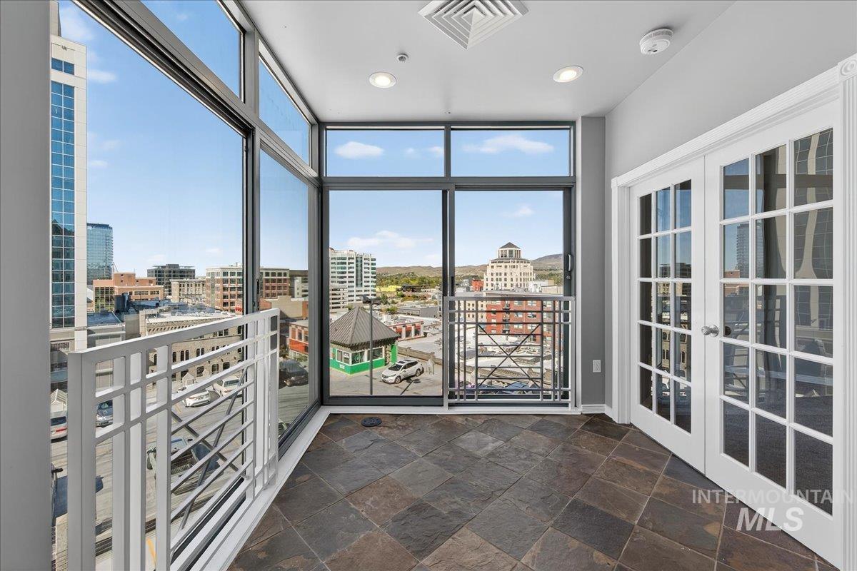 Unfurnished sunroom with a city view and french doors