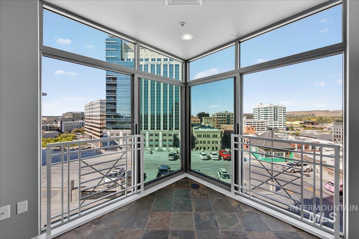Unfurnished sunroom with a view of city and healthy amount of natural light