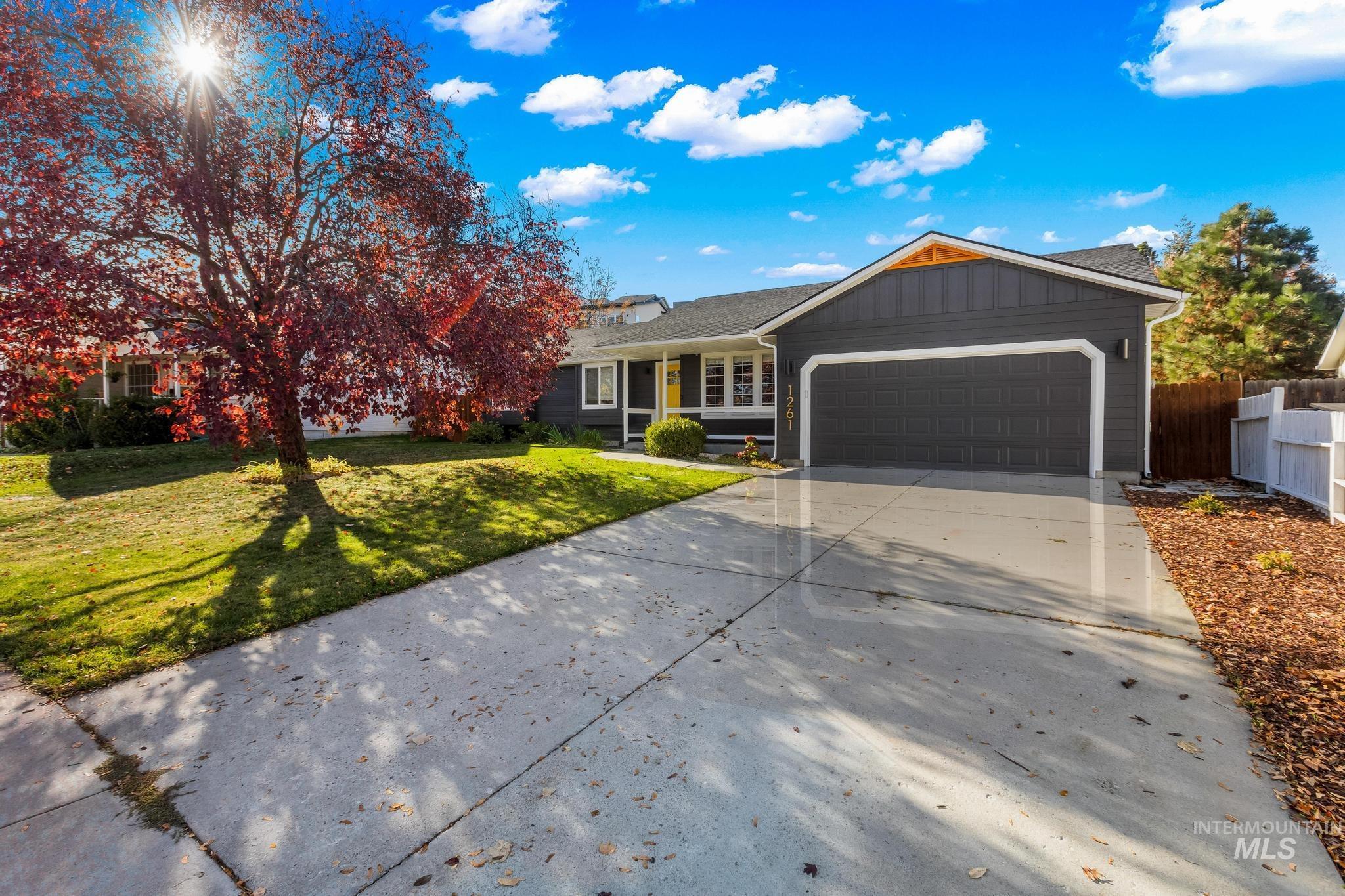 Ranch-style home featuring concrete driveway, an attached garage, and board and batten siding