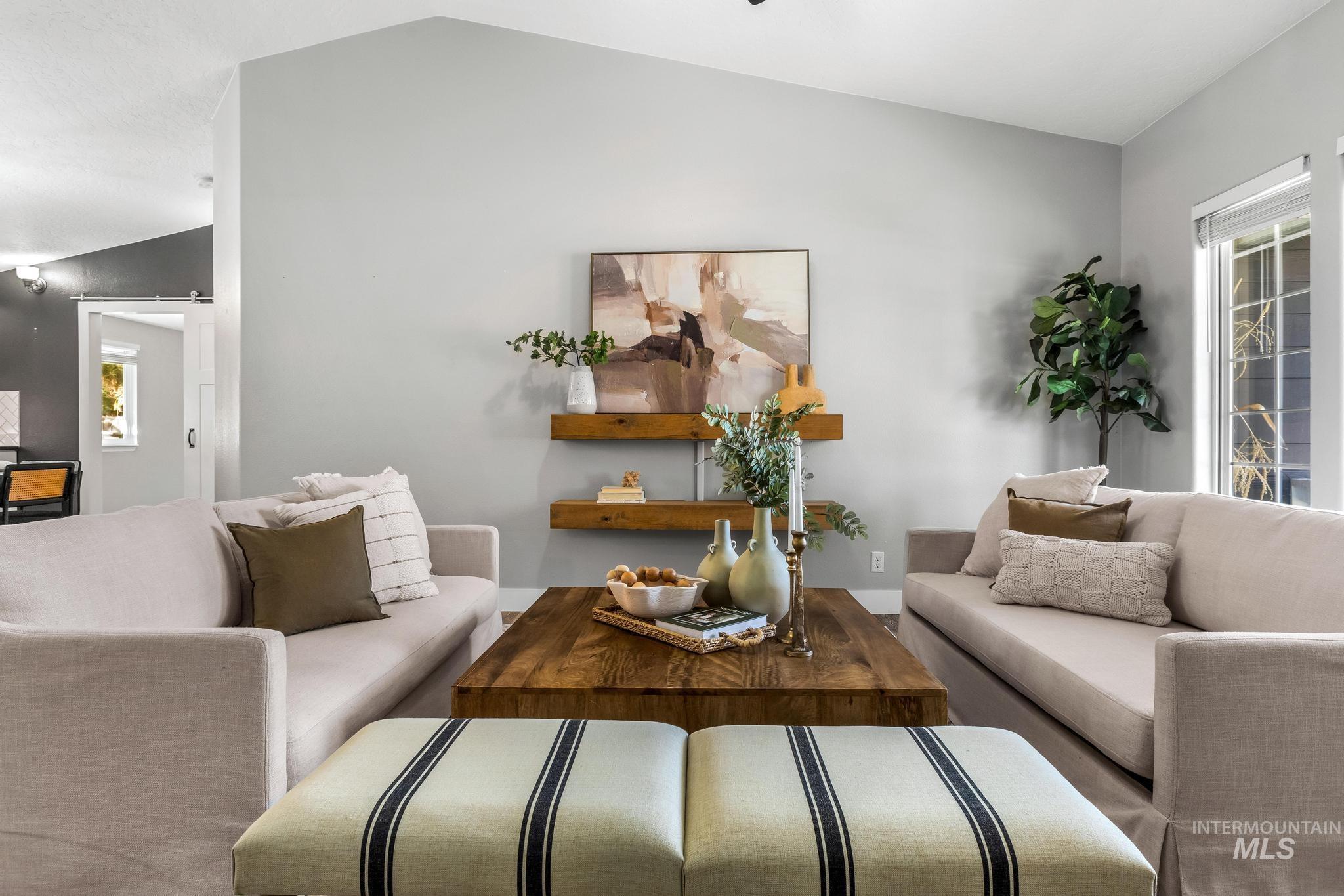 Living area featuring lofted ceiling and baseboards