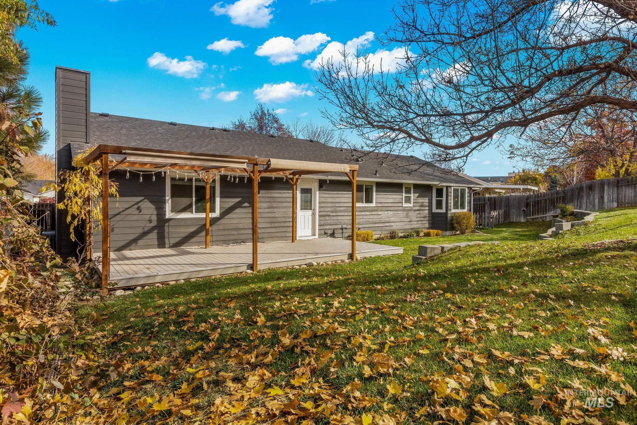 Rear view of house featuring a chimney, a fenced backyard, and a shingled roof