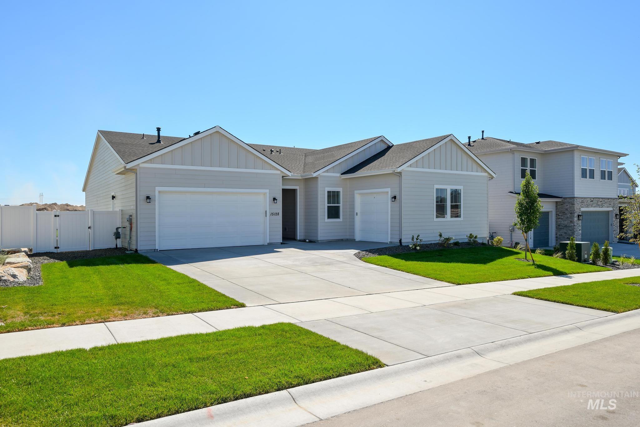 Ranch-style home featuring board and batten siding, a gate, driveway, a shingled roof, and an attached garage
