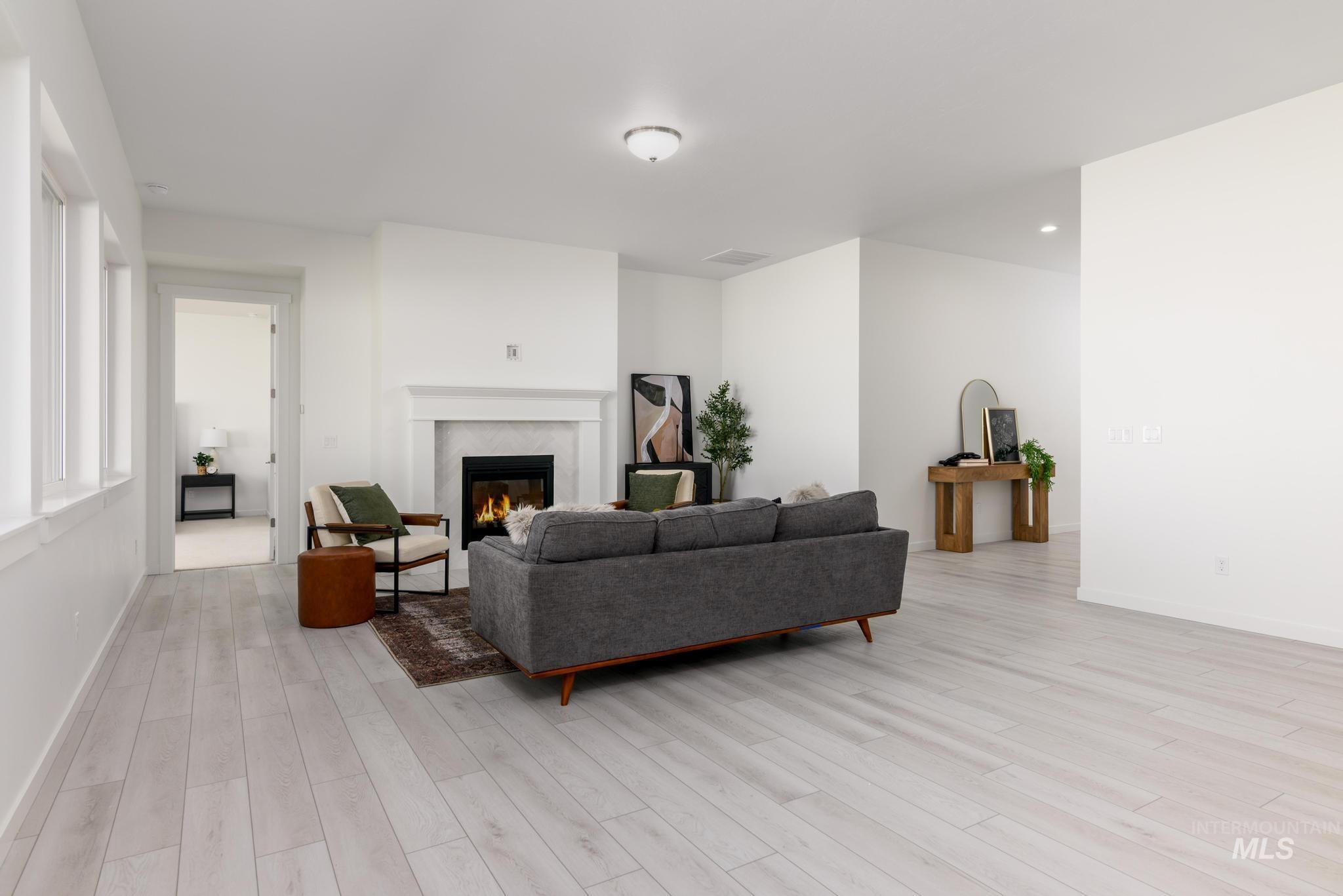 Living room featuring a fireplace, light wood-style floors, and recessed lighting