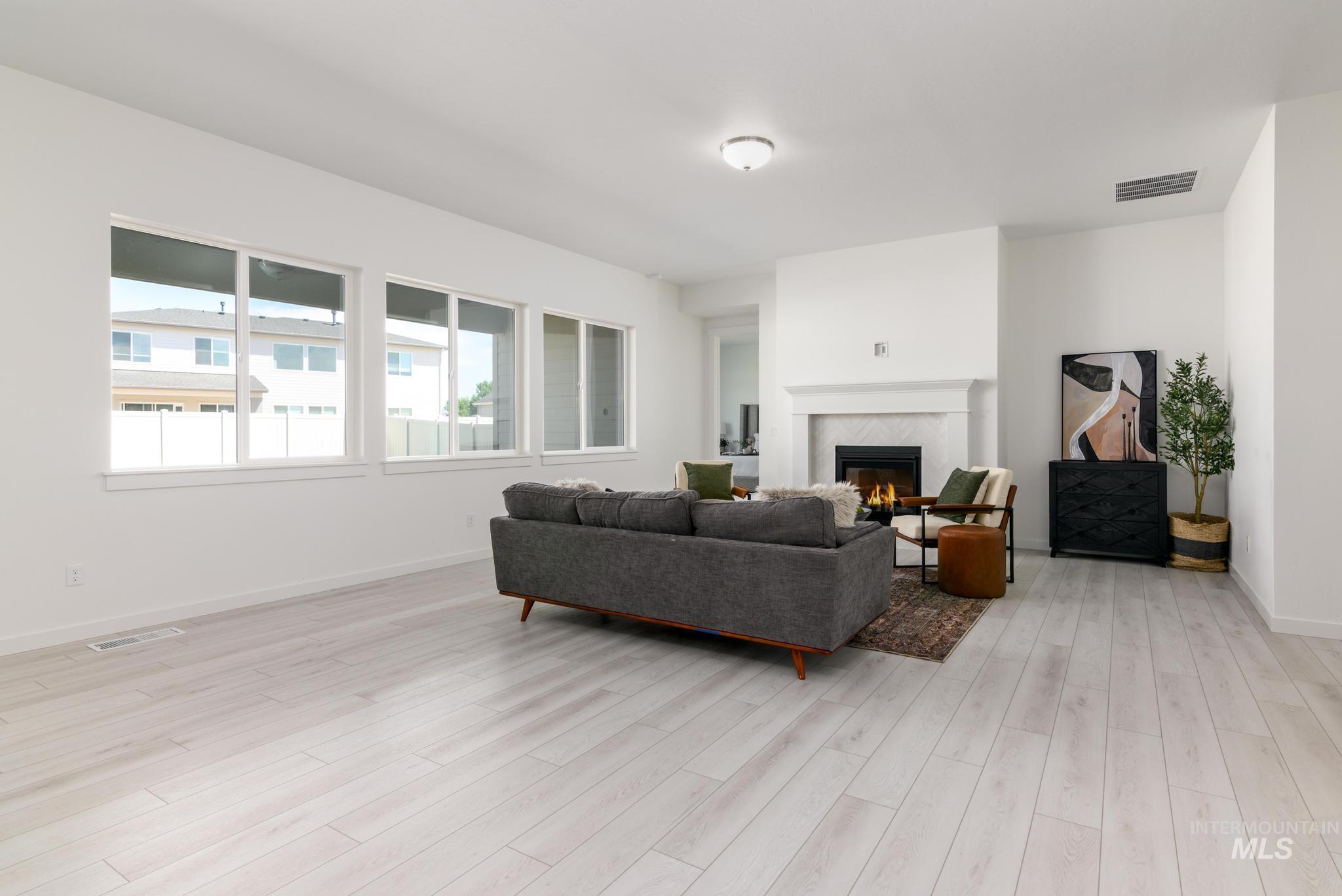 Living room with a glass covered fireplace and light wood-style flooring