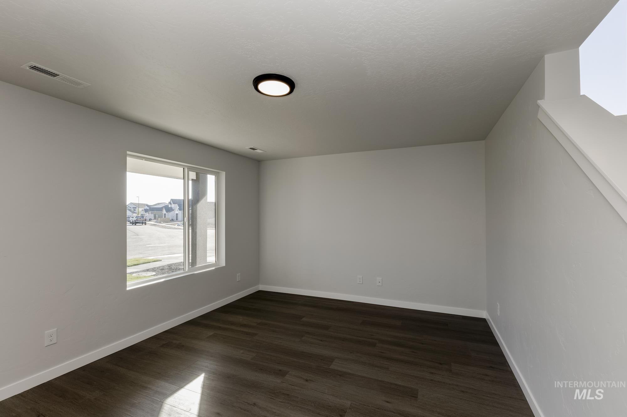 Unfurnished room with dark wood finished floors and baseboards