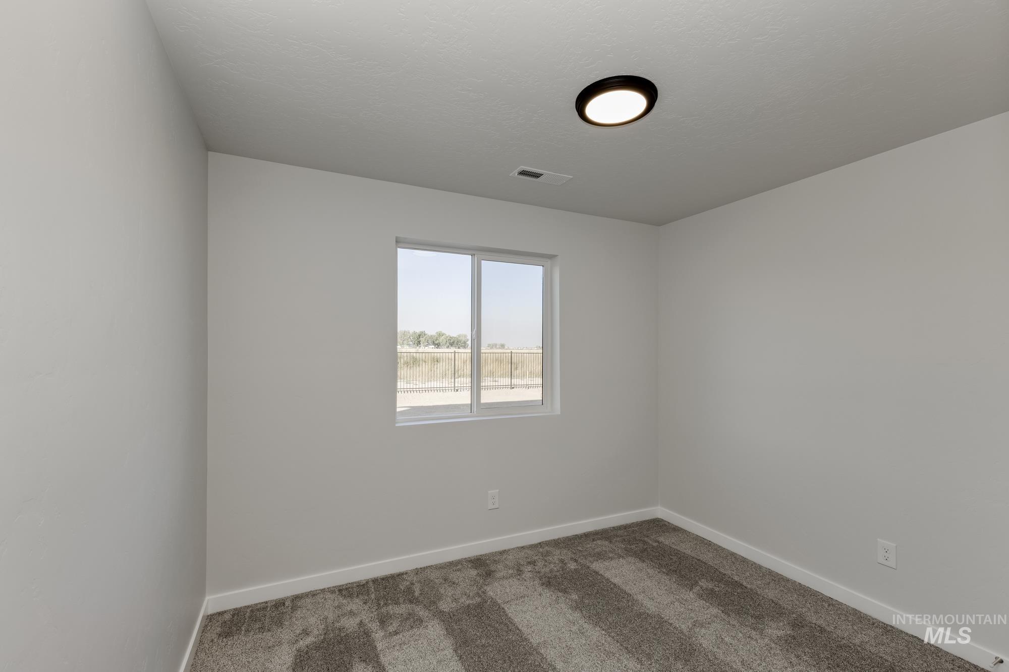 Unfurnished room with carpet and a textured ceiling