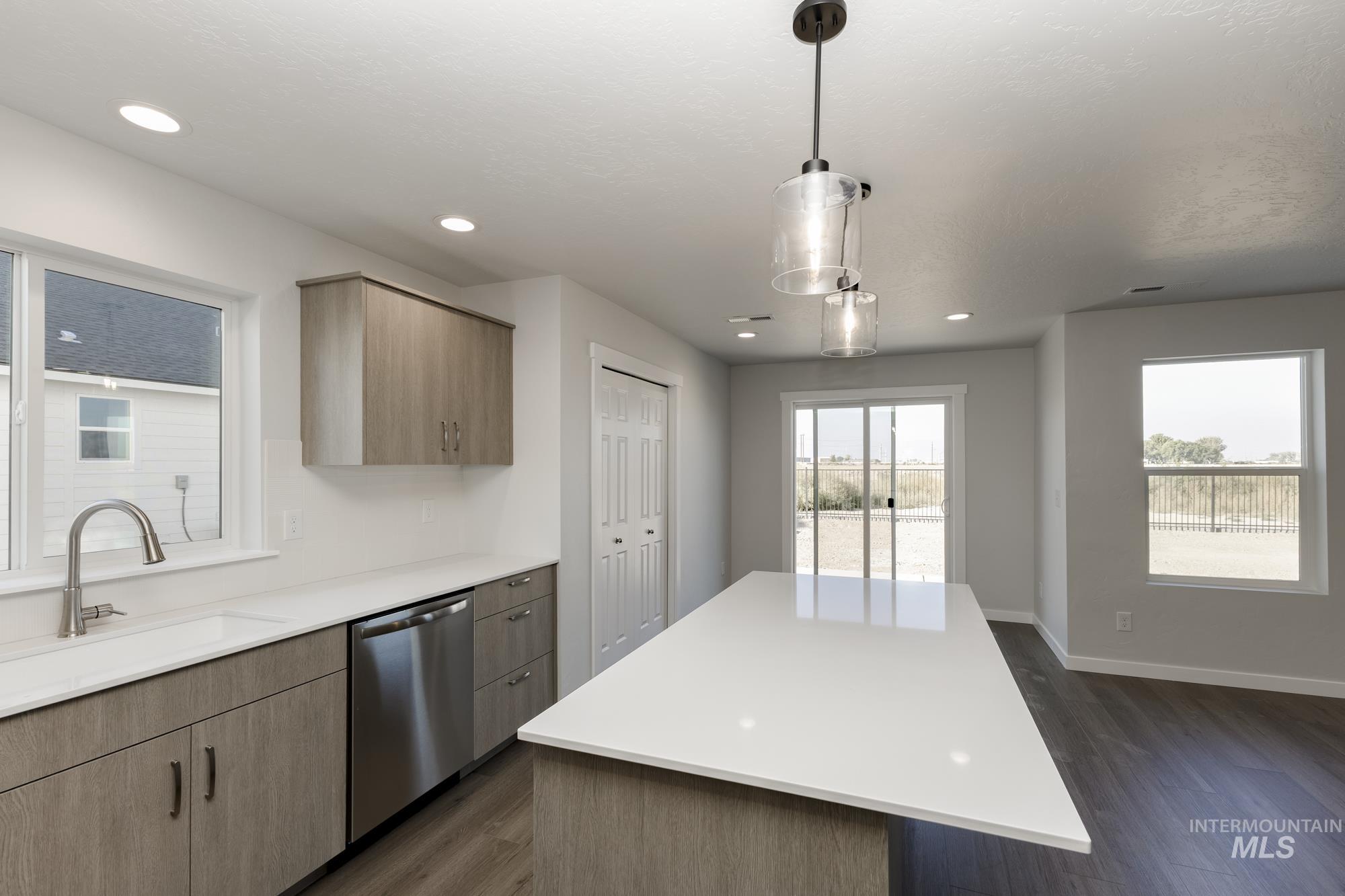 Kitchen with dishwasher, dark wood-type flooring, decorative light fixtures, recessed lighting, and modern cabinets