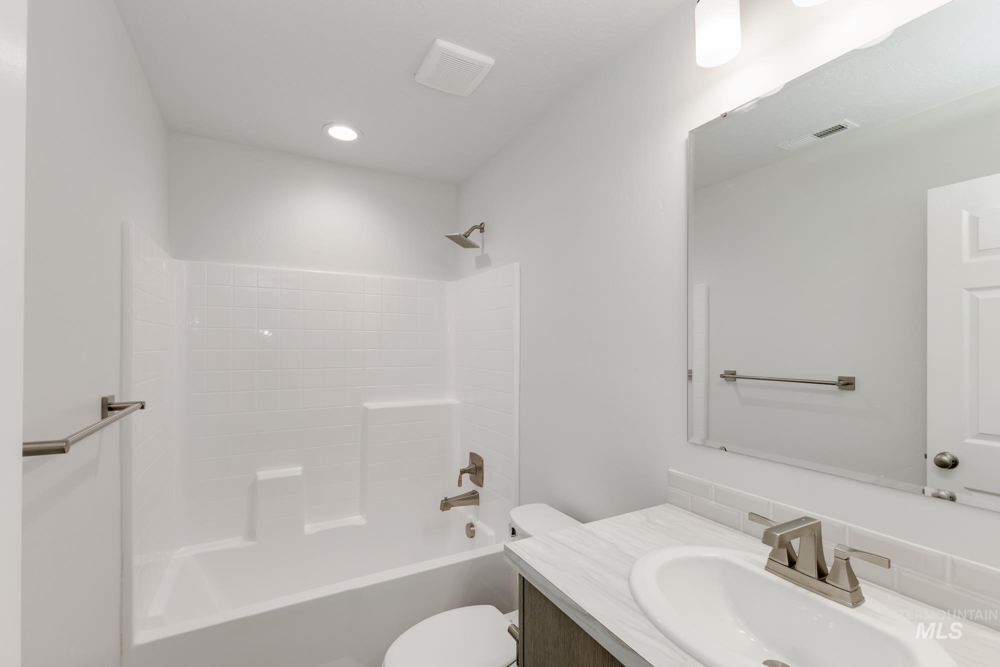 Bathroom with vanity, tub / shower combination, and recessed lighting
