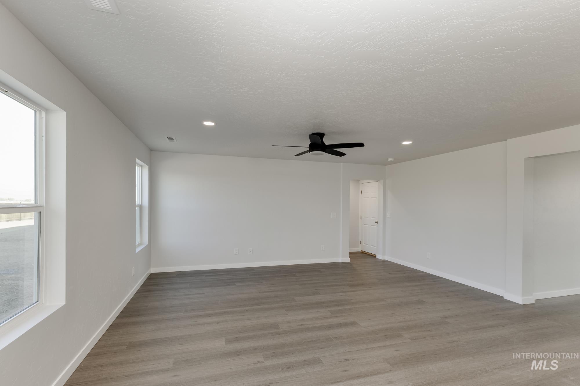 Spare room featuring light wood-style floors, recessed lighting, a ceiling fan, and a textured ceiling