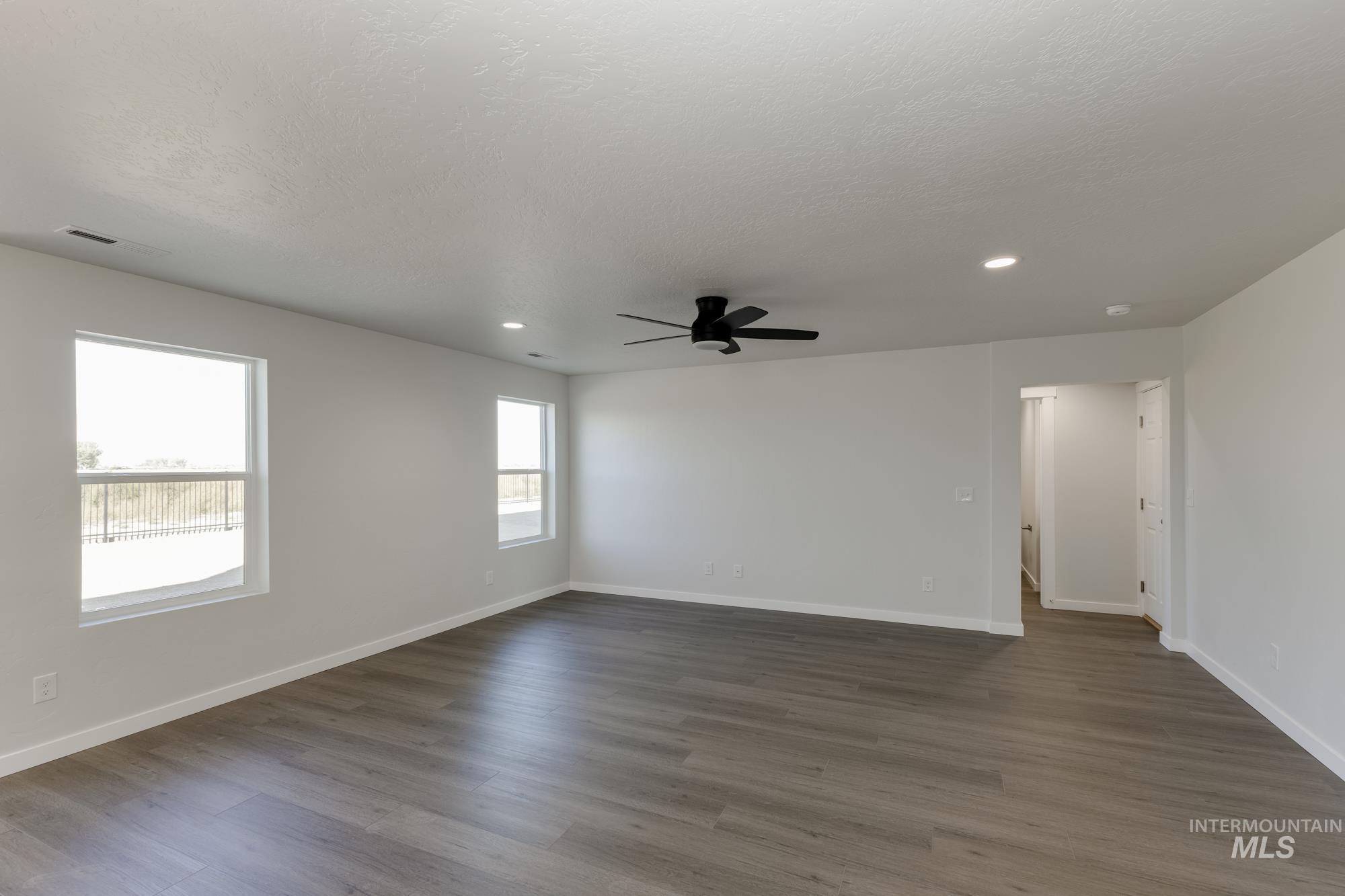 Empty room featuring dark wood-style floors, recessed lighting, and ceiling fan